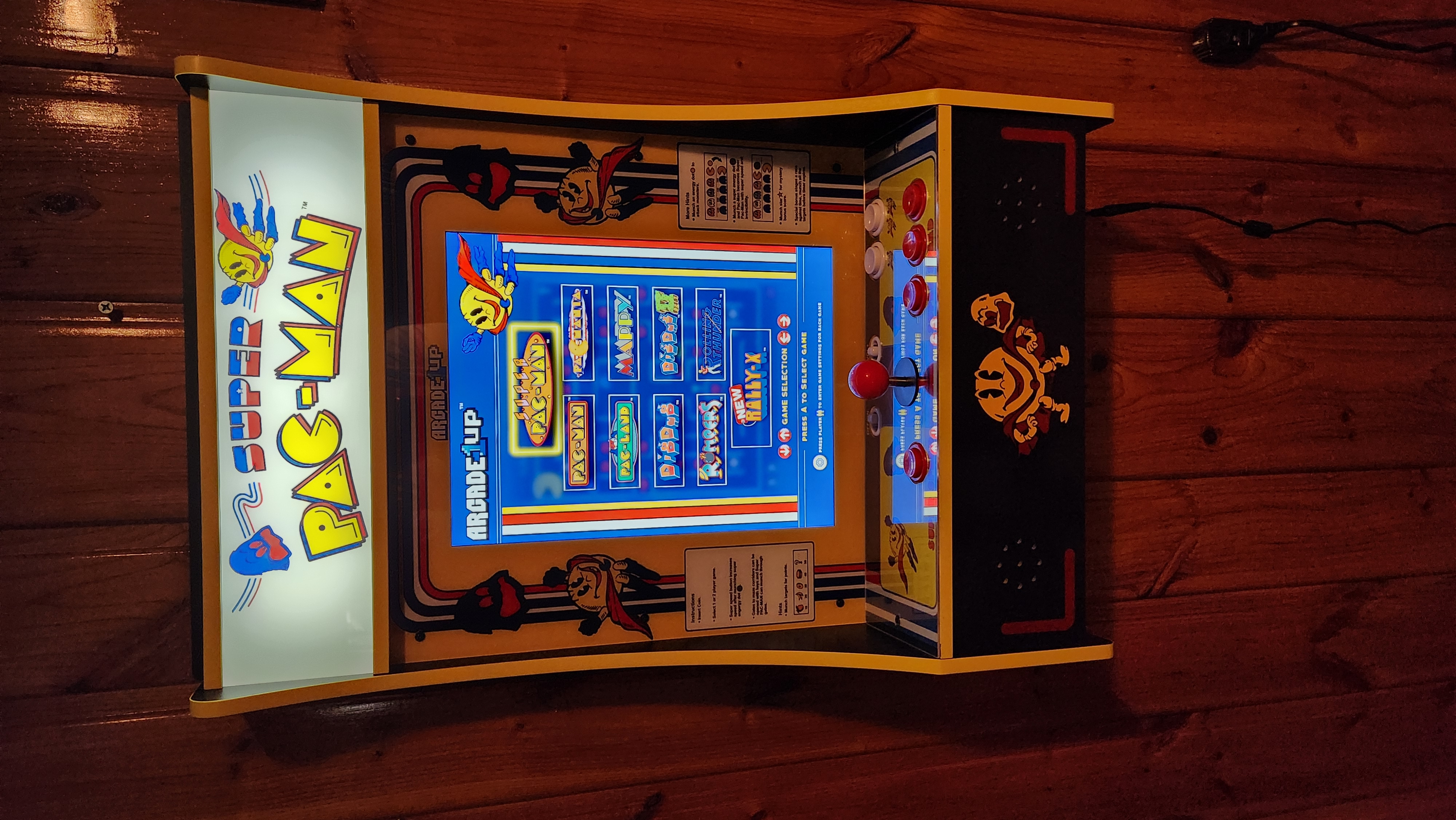 A classic 'Super Pac-Man' arcade cabinet featuring a colorful menu and retro design.