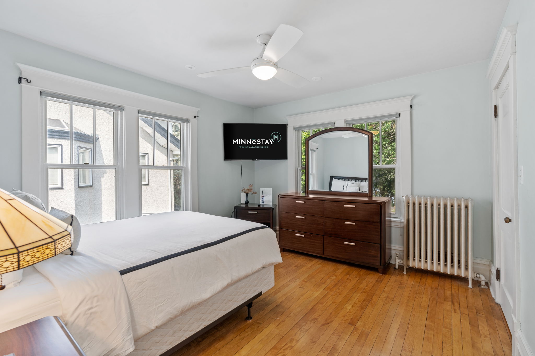 A serene and stylish bedroom featuring a modern design and ample natural light.