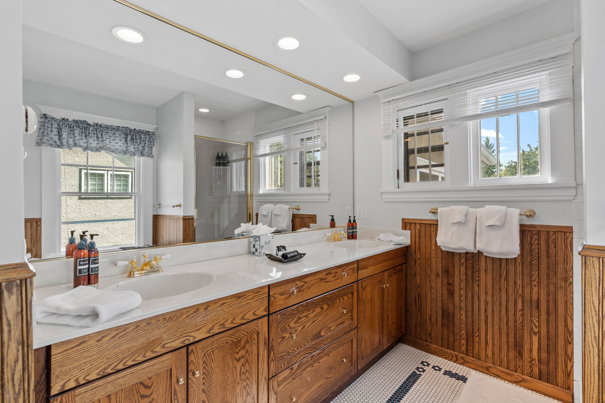Stylish and serene bathroom with rich wooden cabinetry and marble accents.