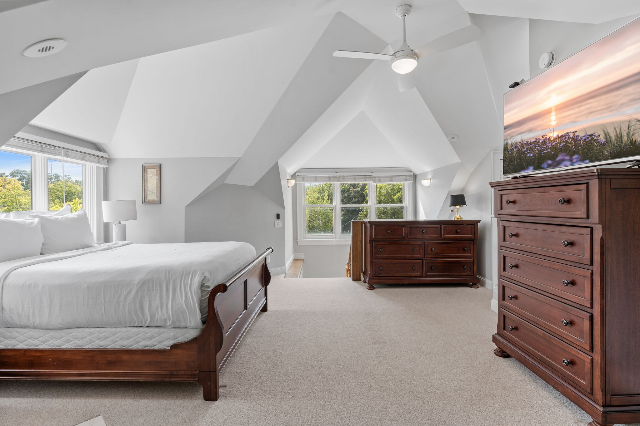 A serene and spacious bedroom with vaulted ceilings and elegant furnishings.