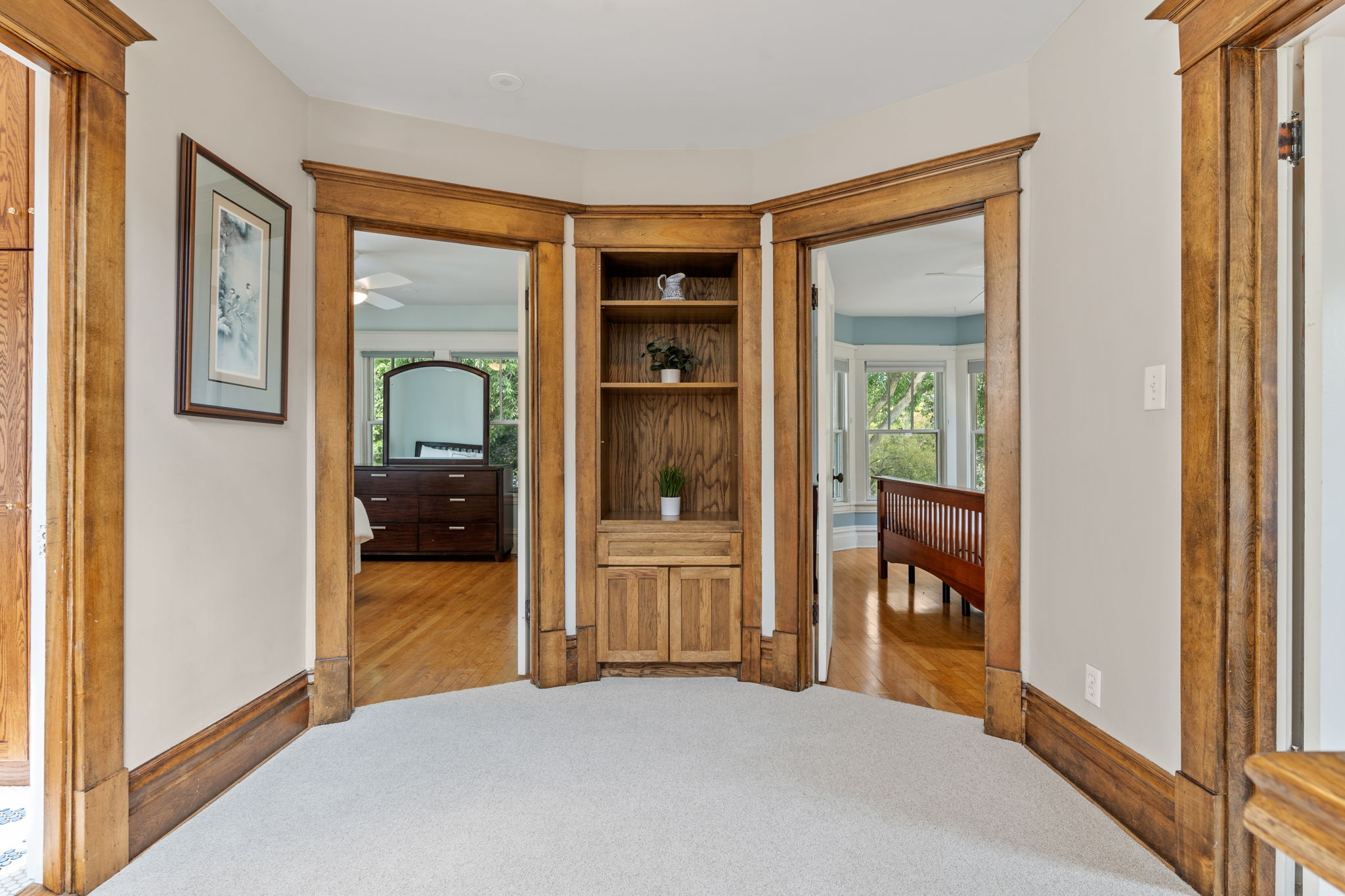 A beautifully crafted corner nook with an elegant built-in shelf and access to bright, spacious rooms.