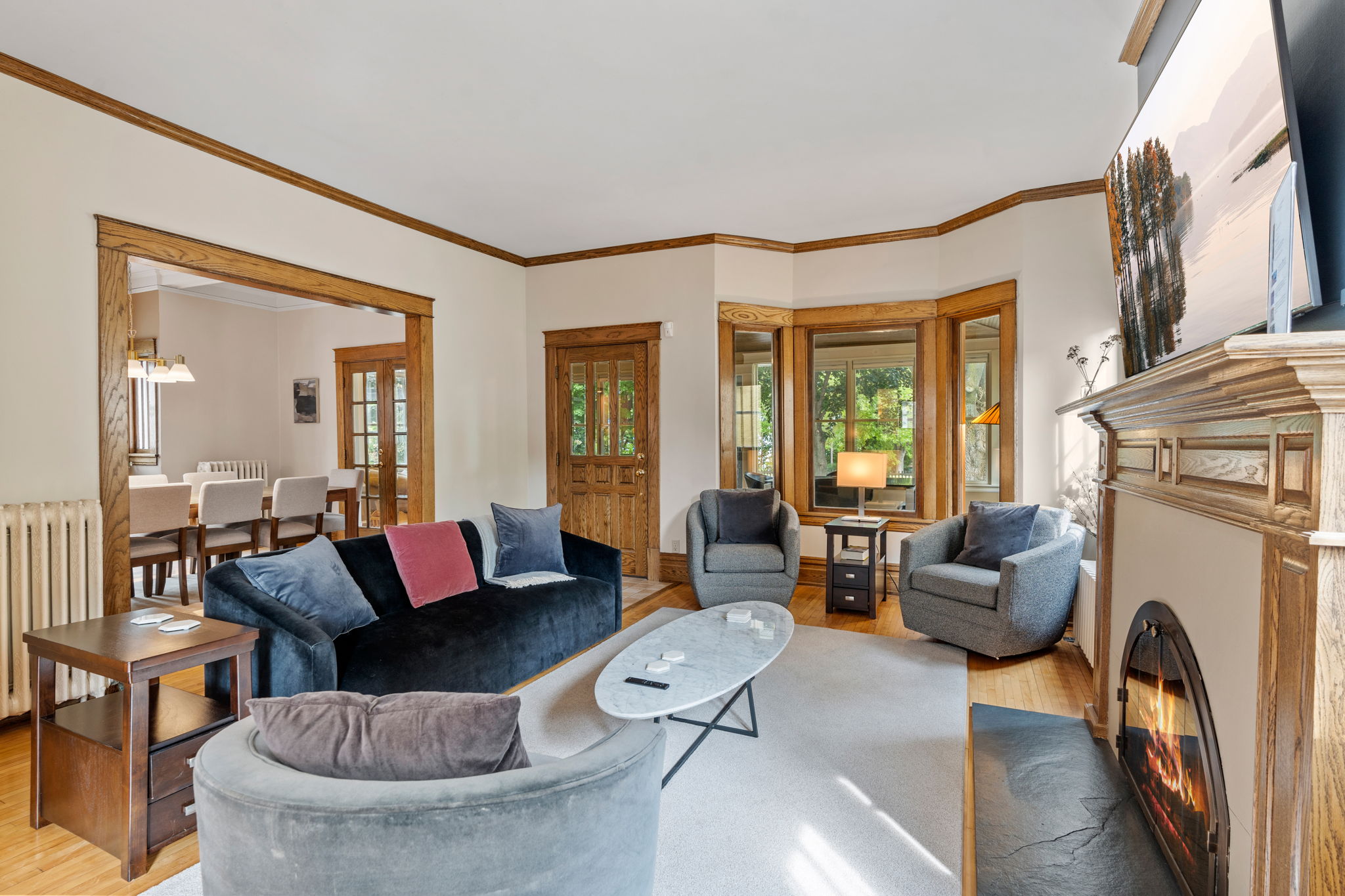 A cozy living room with elegant woodwork and sunlight pouring in.
