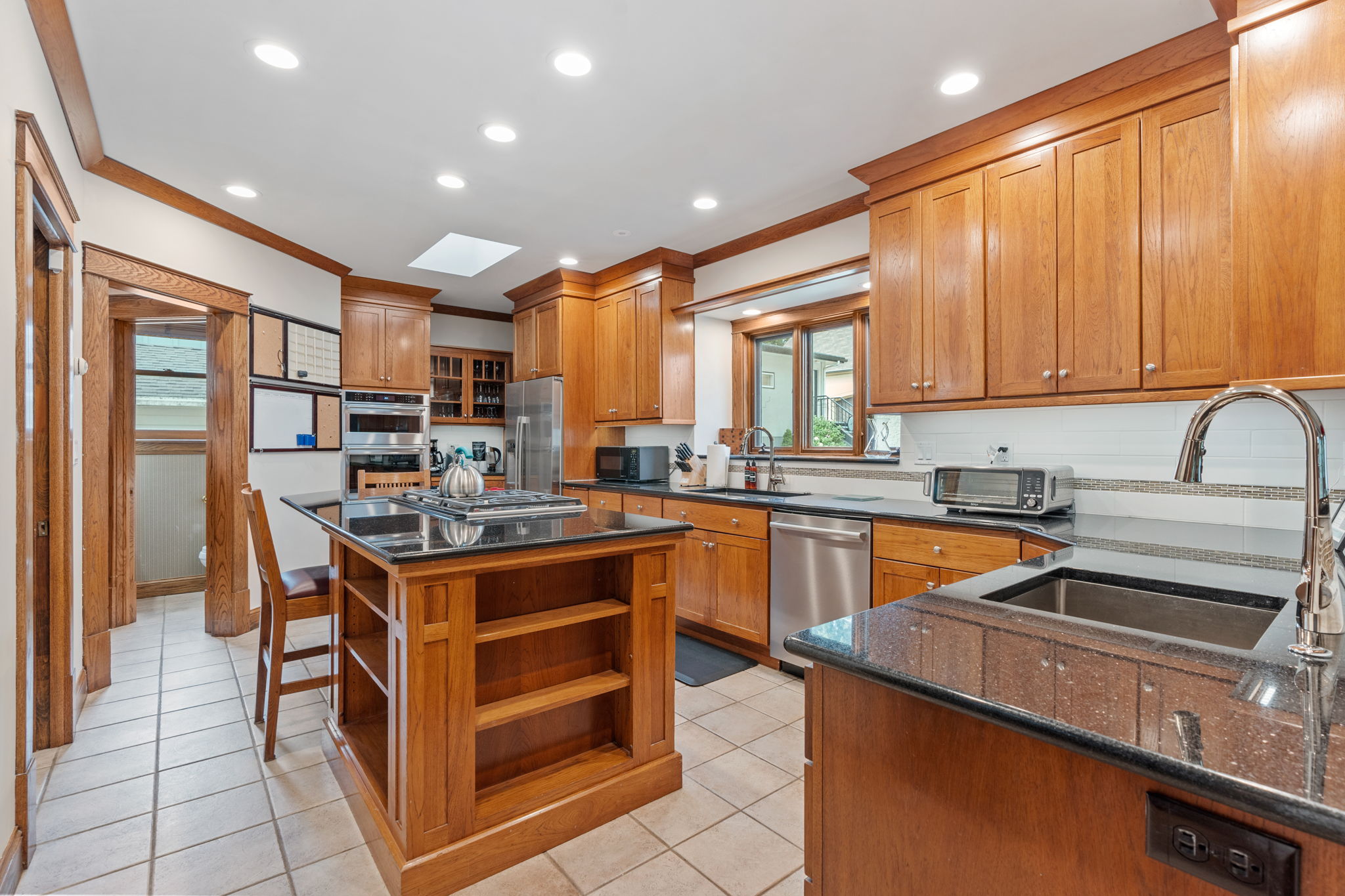 A modern kitchen with wooden cabinets and granite countertops.