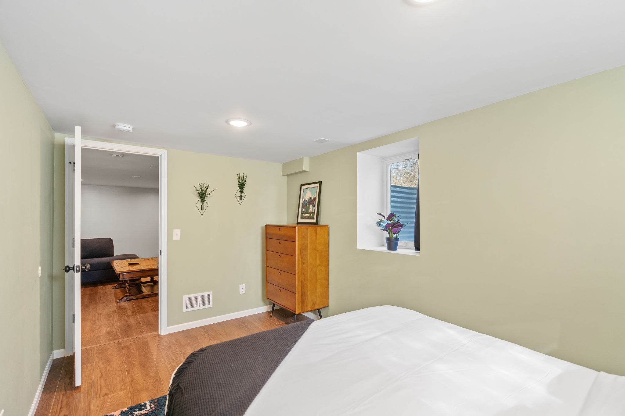 A cozy green-themed bedroom showcasing modern decor and natural elements.