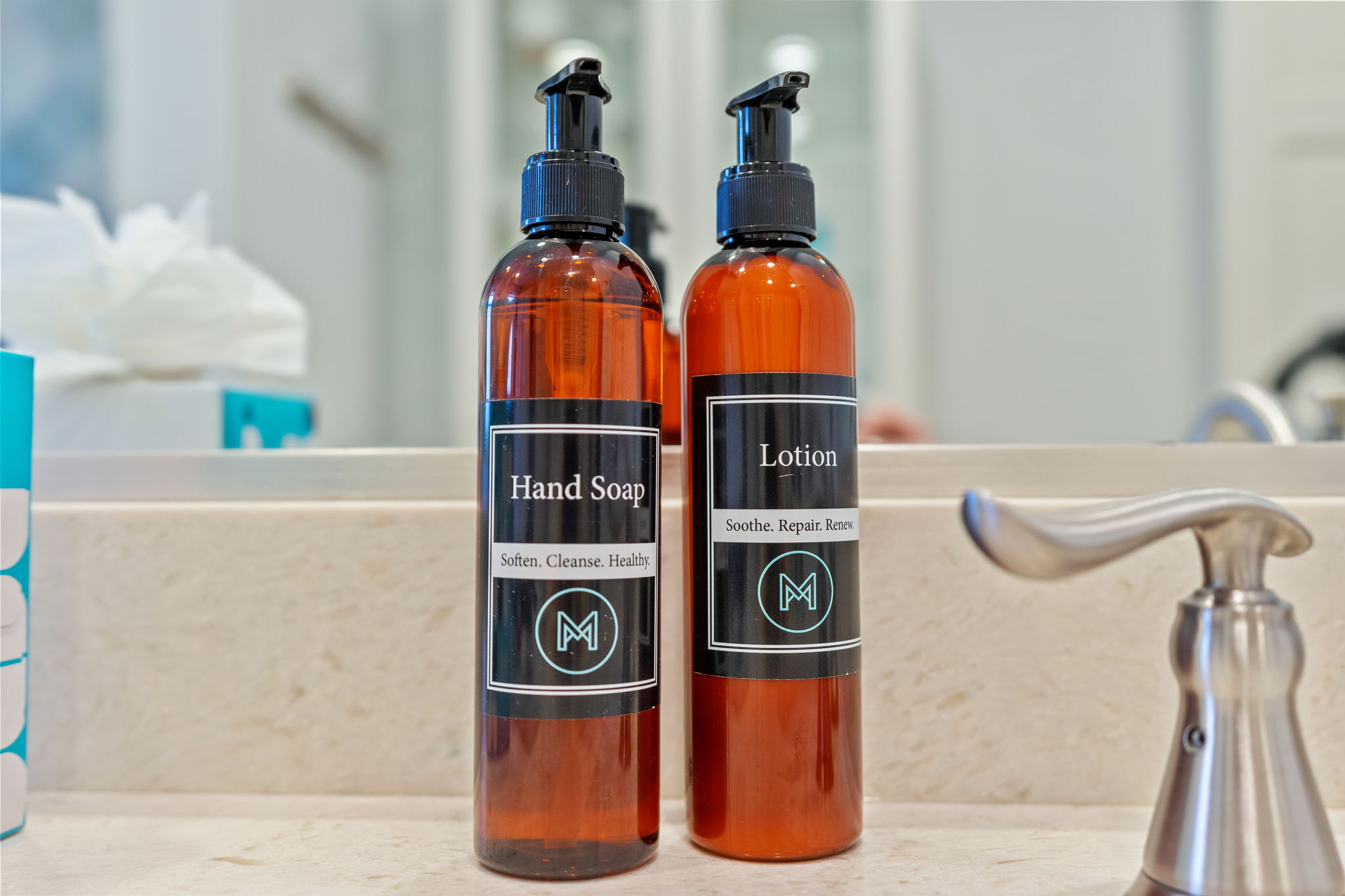 Amber bottles of hand soap and lotion on a bathroom counter.