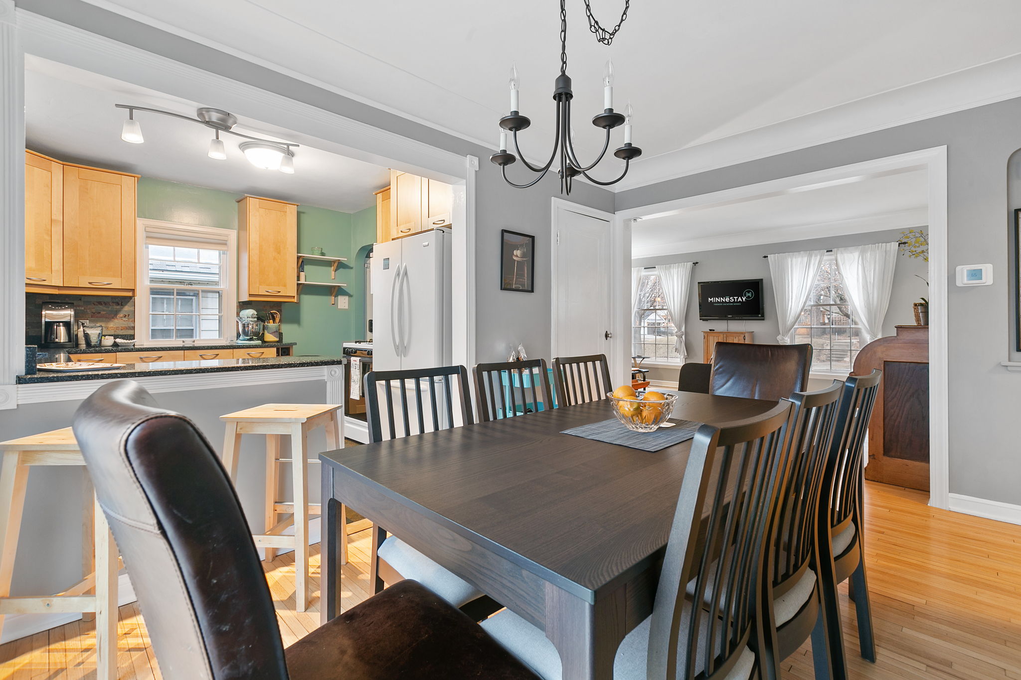 A warm dining area connected to a modern kitchen, filled with natural light and inviting decor.