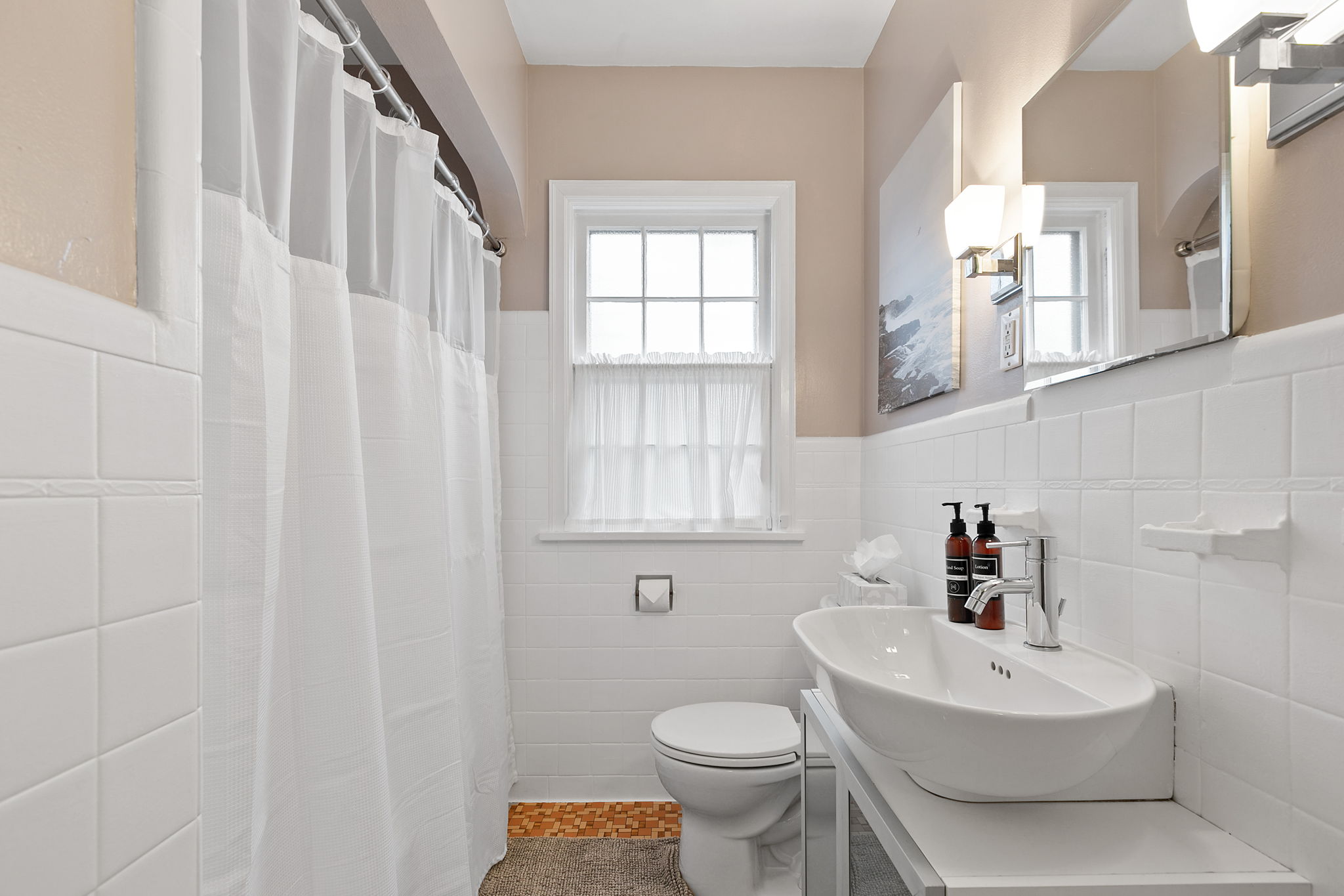 A modern and bright bathroom featuring elegant fixtures and natural light.