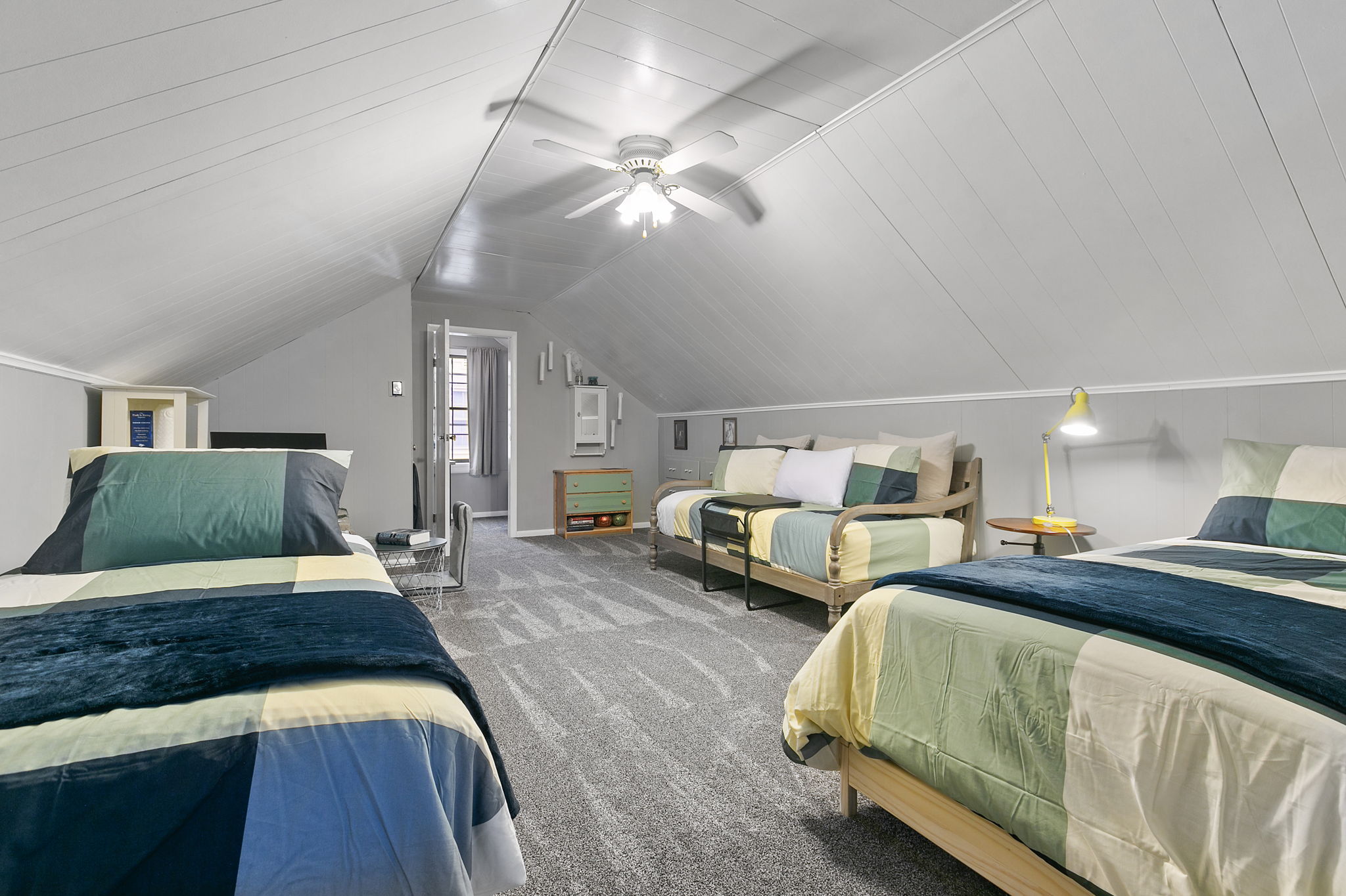 Cozy attic bedroom with colorful patchwork bedding and inviting decor.