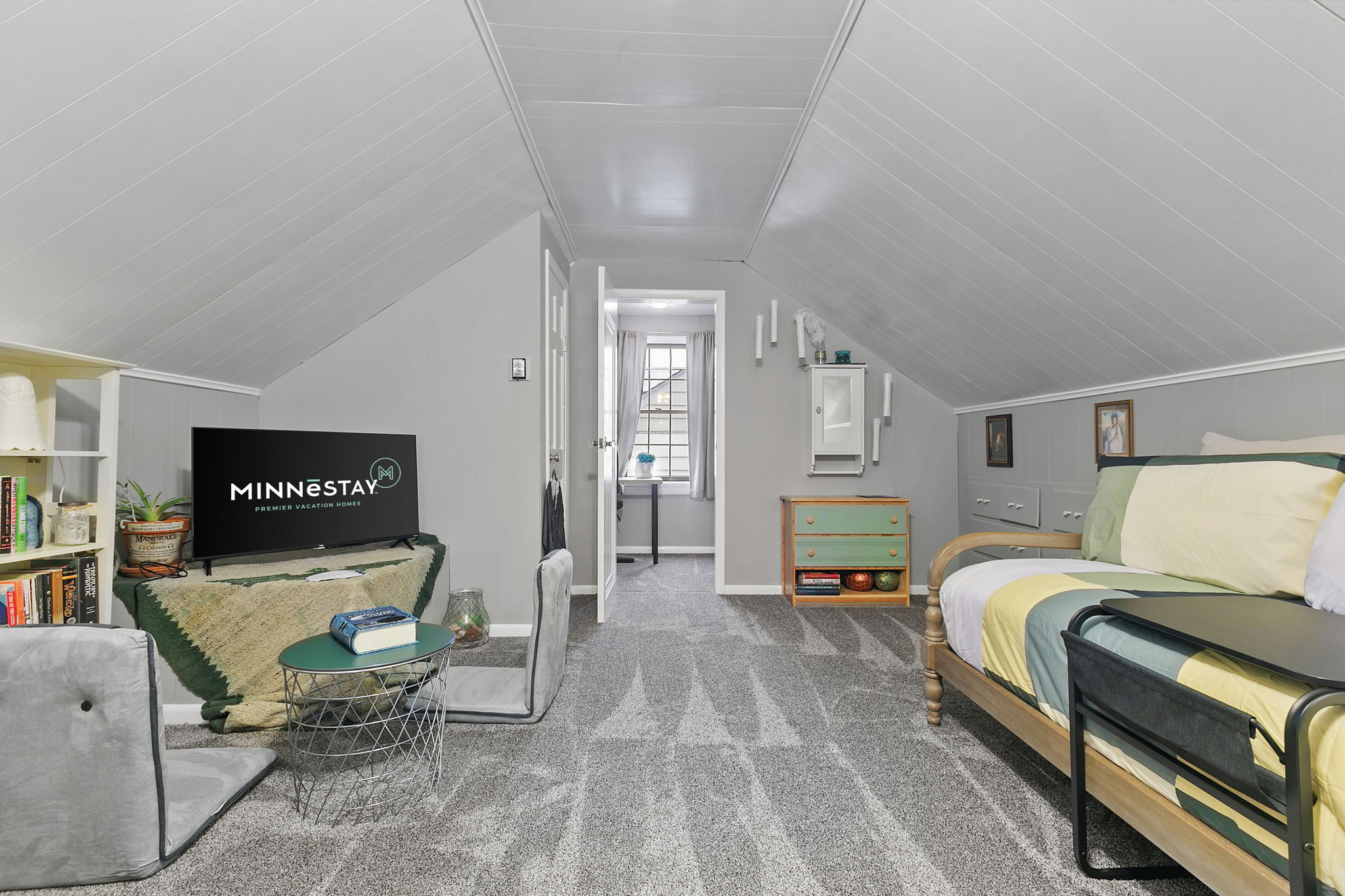 A cozy attic space featuring a bed, seating area, and modern decor.