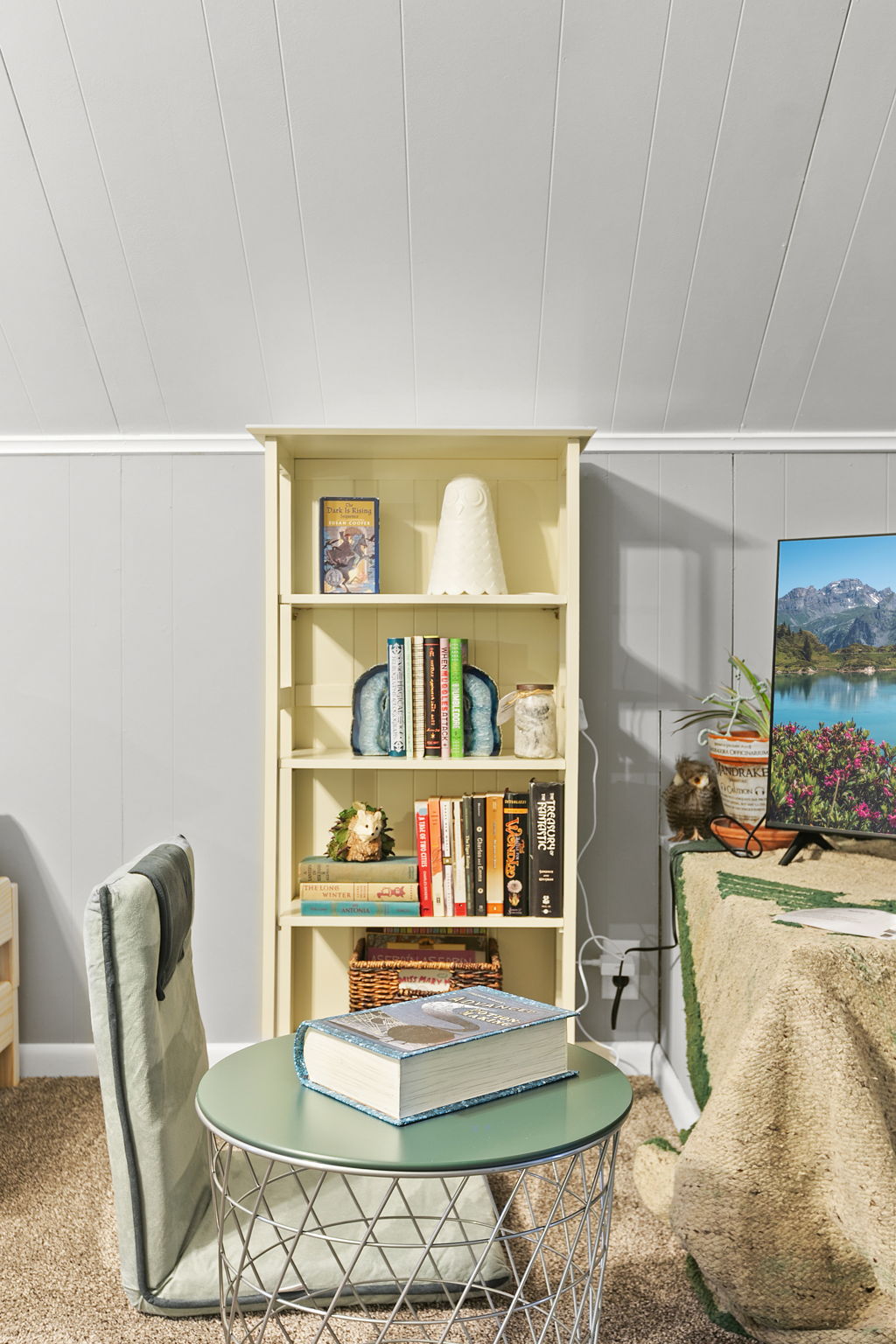A cozy reading nook featuring a cheerful yellow bookshelf and modern decor.