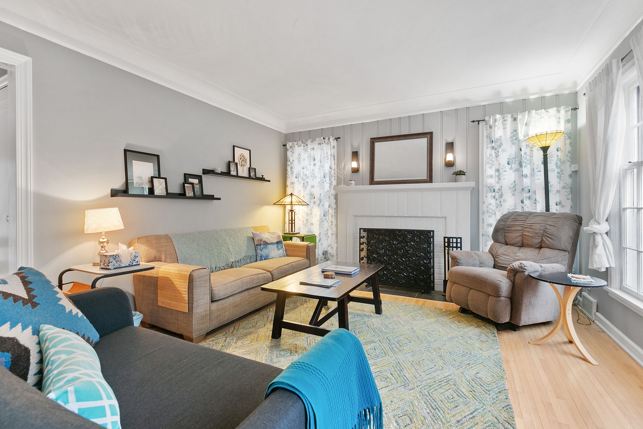 A cozy and stylish living room with a mix of modern and warm décor, featuring plush seating, personal accents, and natural light.