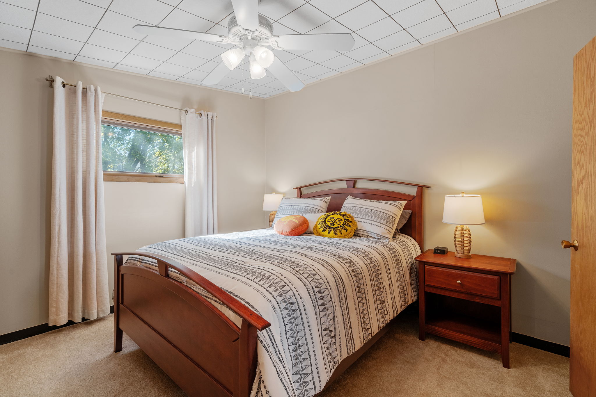 A cozy and inviting bedroom with wooden furniture and soft decor elements.