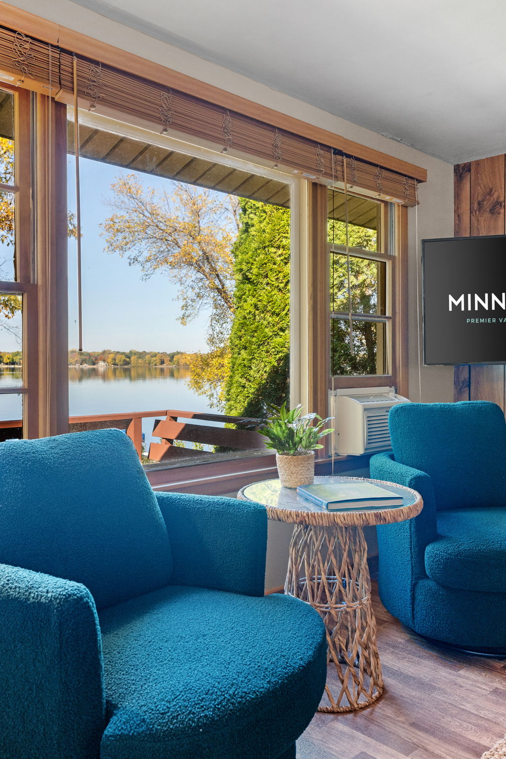 A cozy lakeside living room with plush chairs and a scenic view.