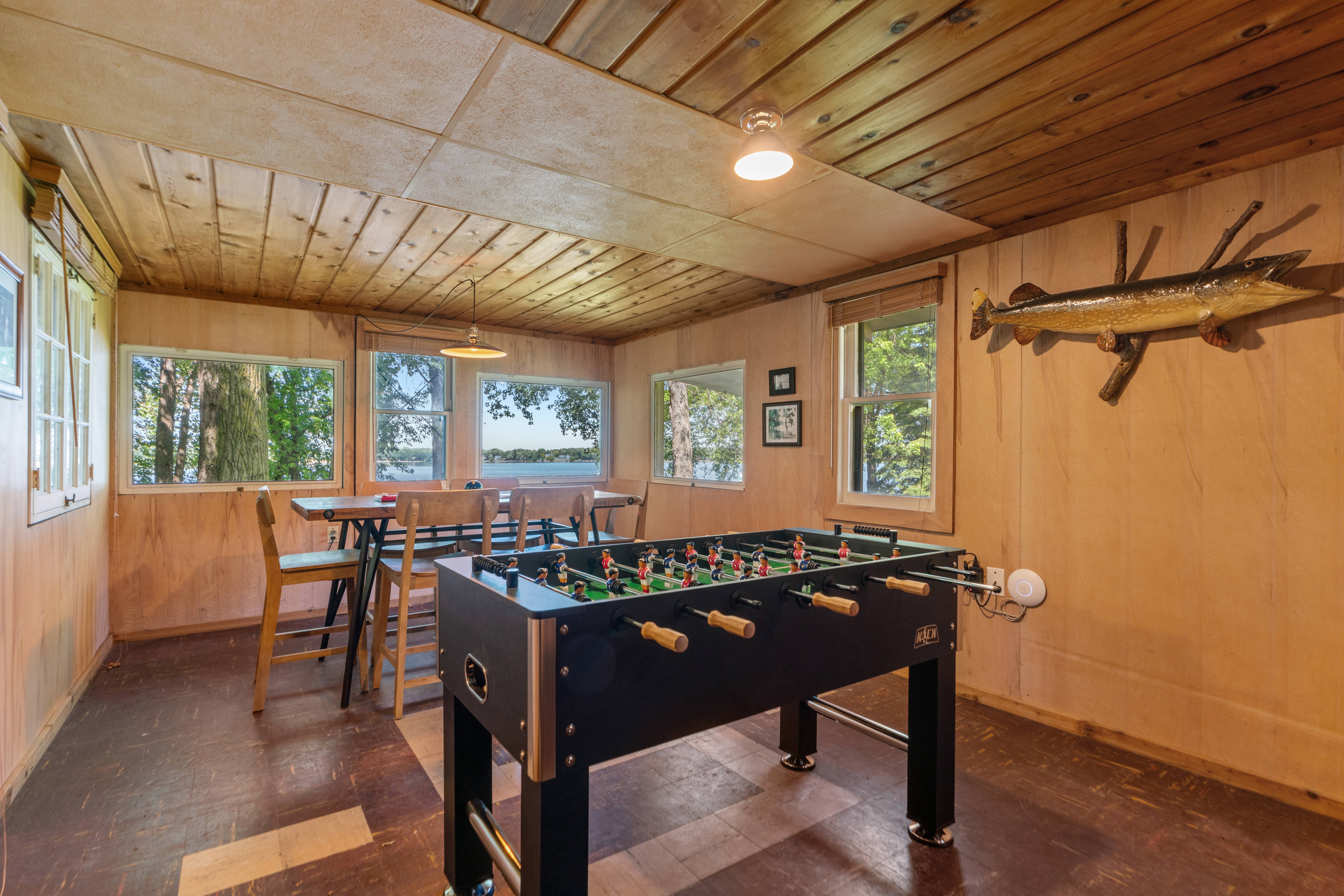 A cozy lakeside recreation room with a foosball table and picturesque views.
