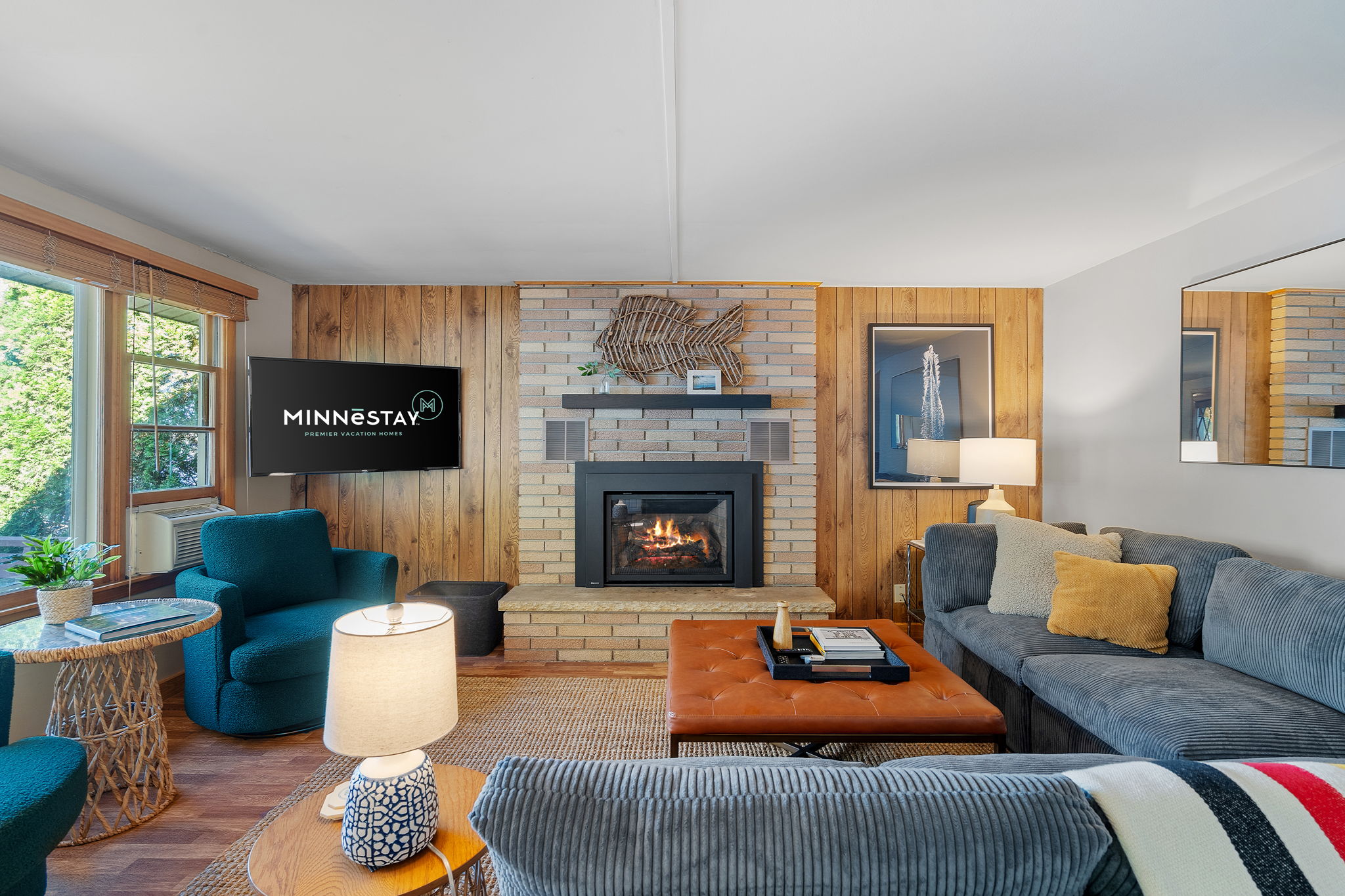 A cozy living room featuring a brick fireplace and modern decor.