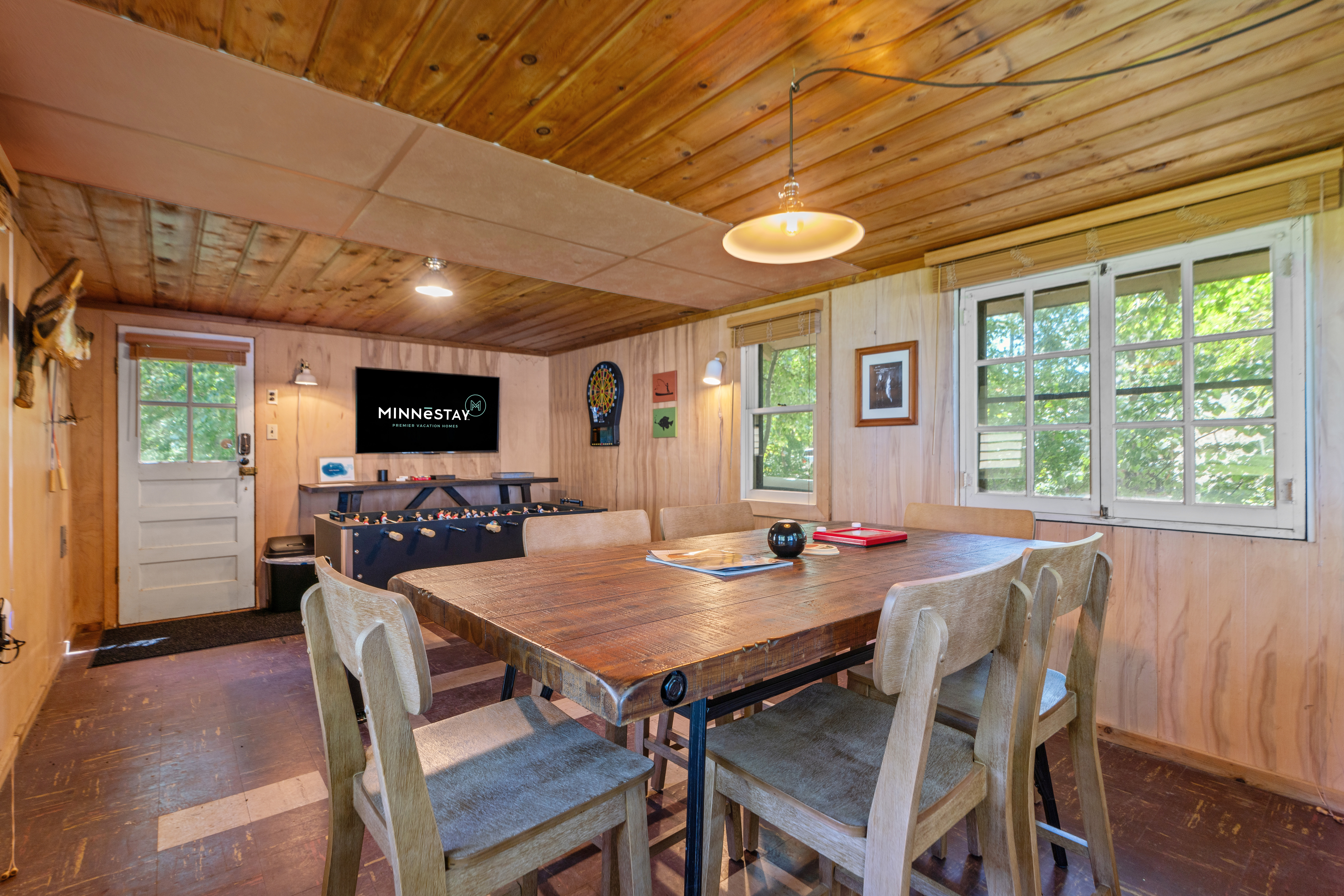 Interior view of a cozy cabin dining area featuring wooden elements and a foosball table.
