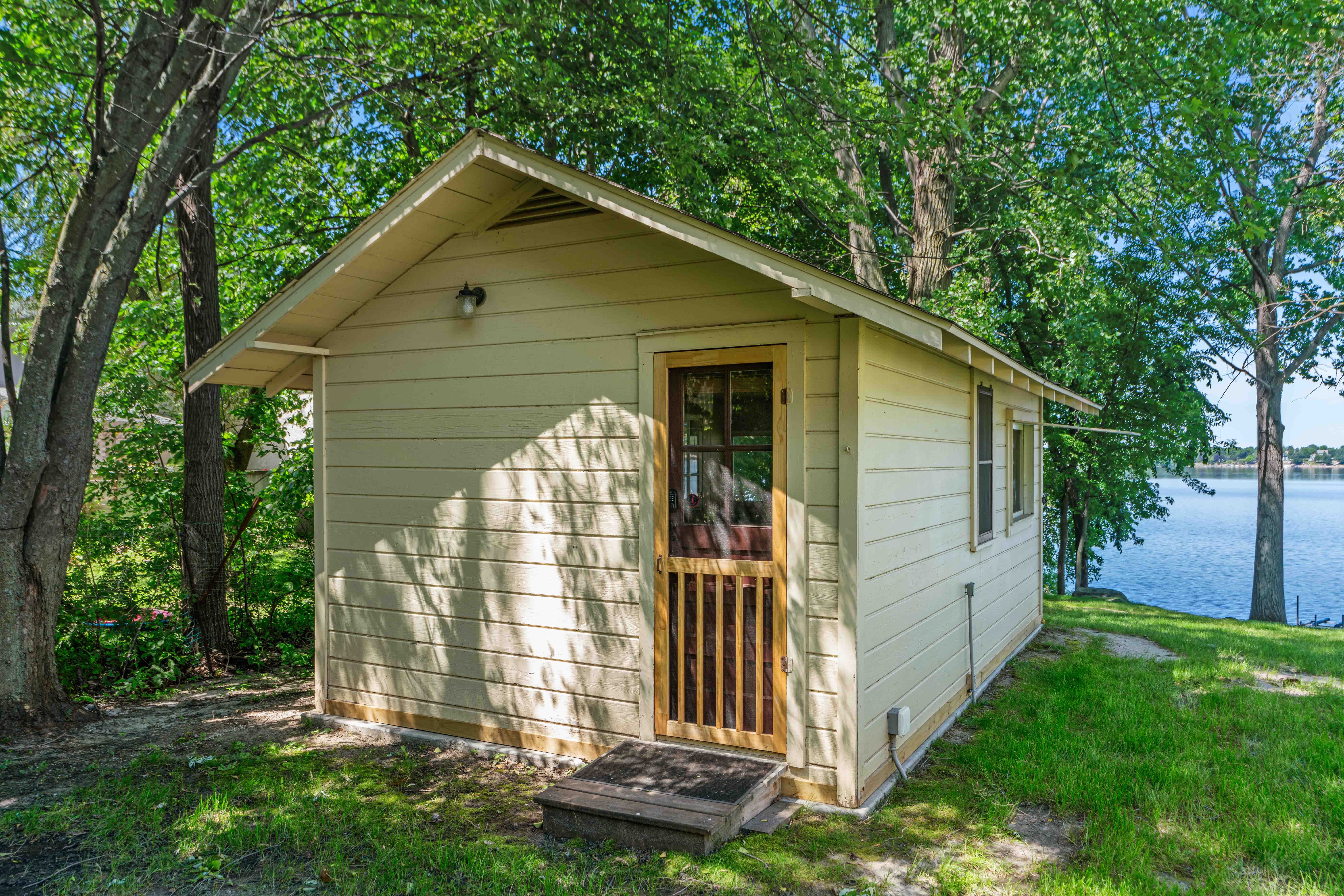 A charming lakeside cabin surrounded by greenery.