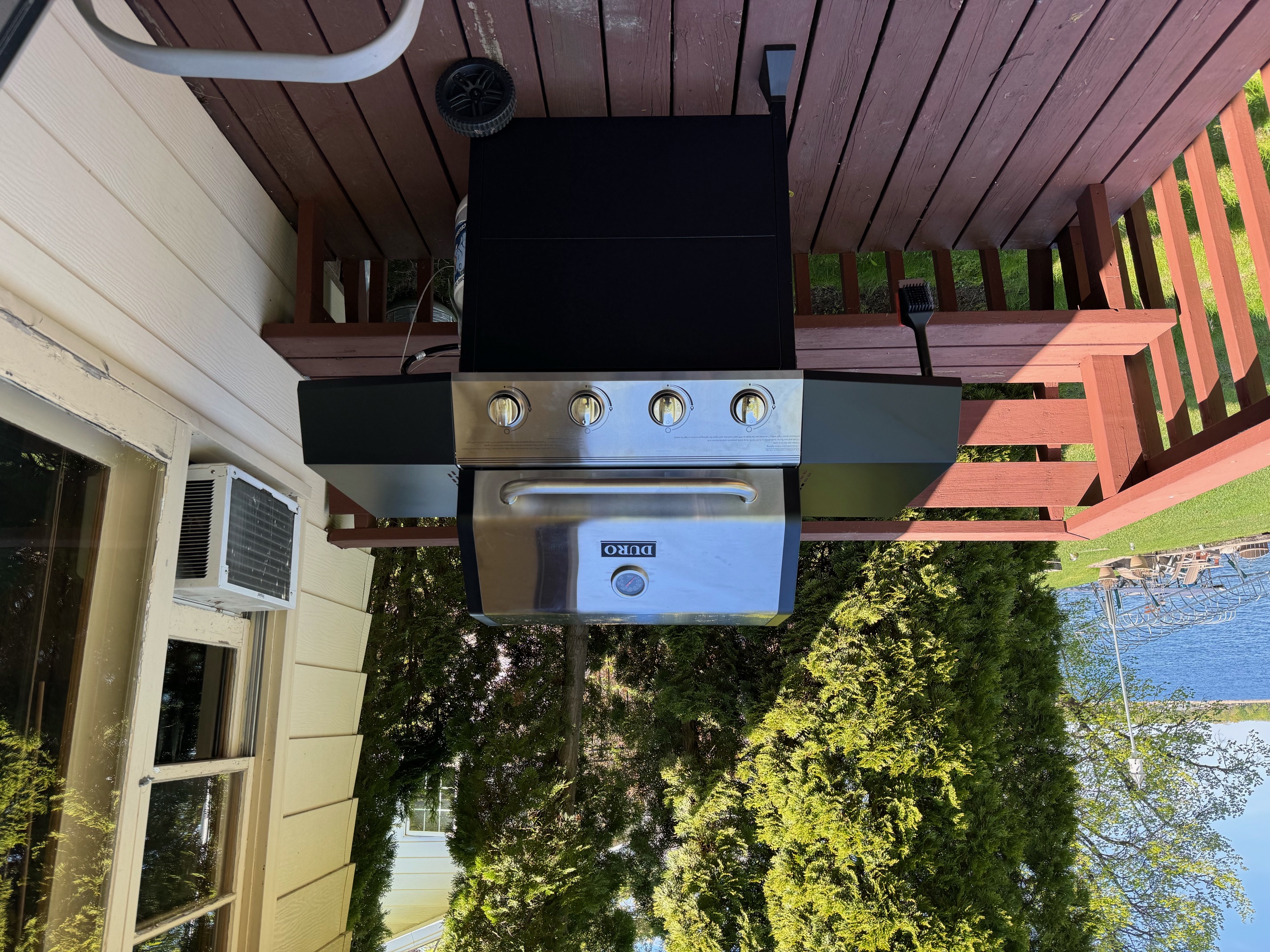 A contemporary gas grill on a lakeside deck, perfect for outdoor cooking.