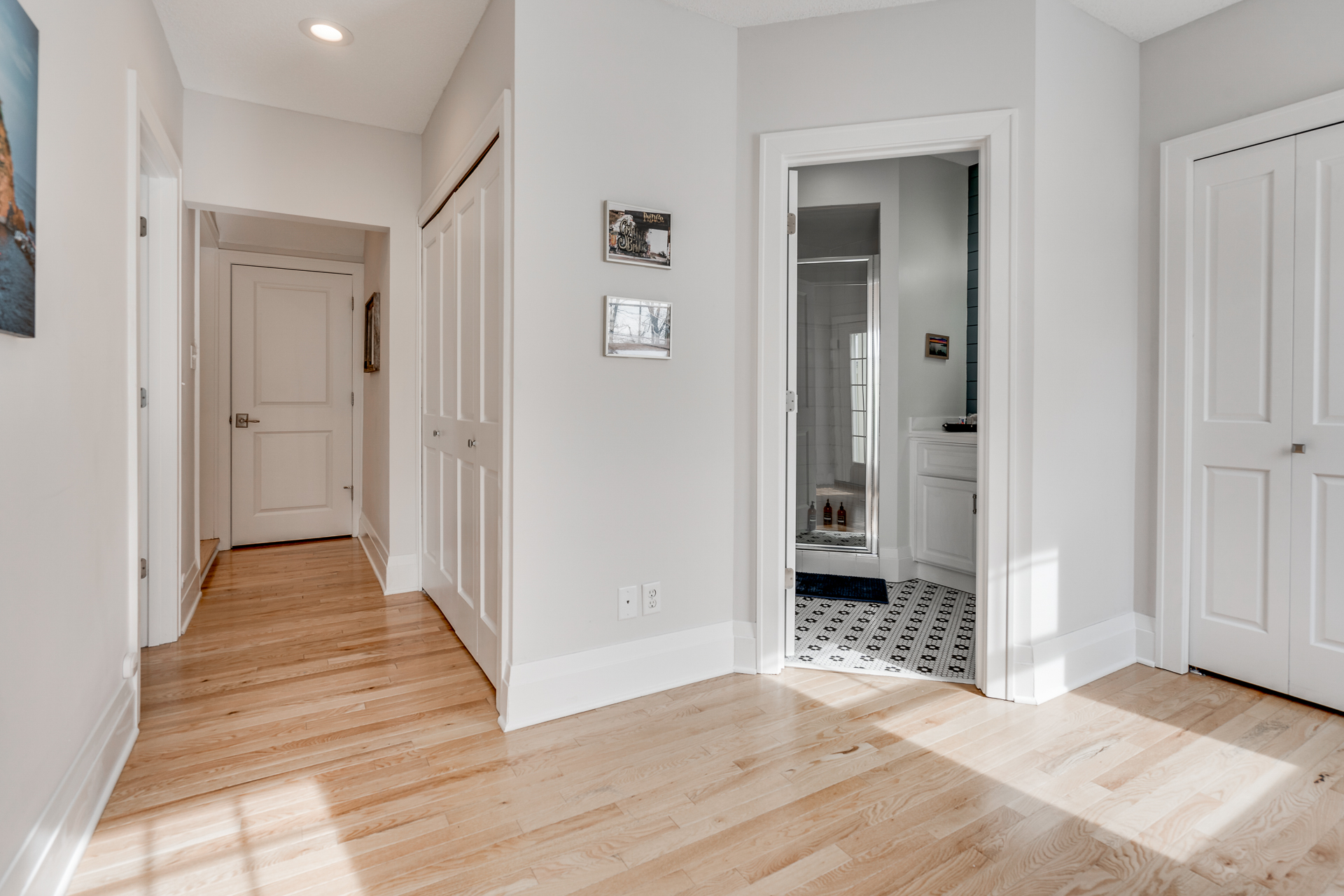 A bright and airy home hallway leading to a modern bathroom.