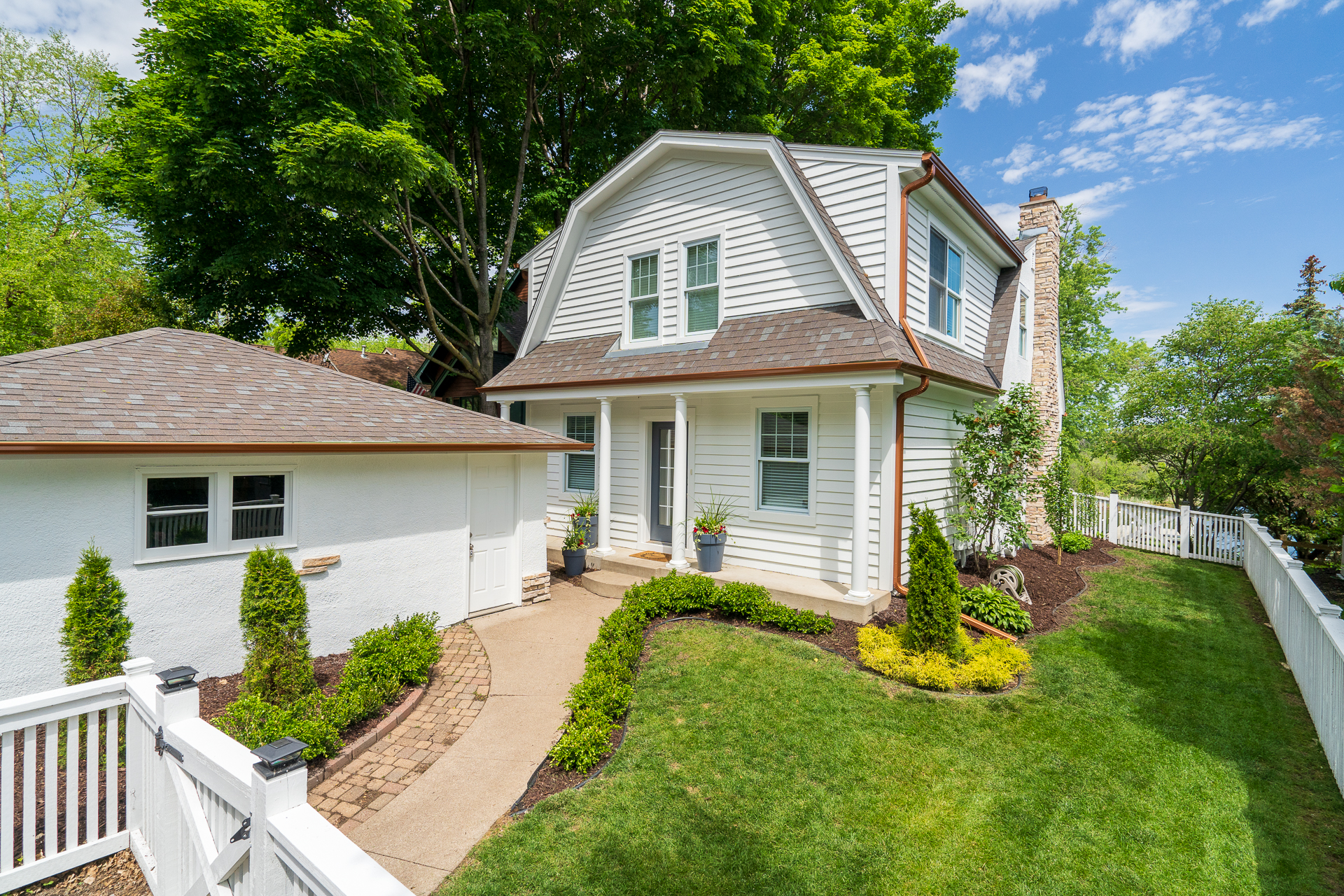 A charming two-story home with a well-kept garden and inviting entrance.