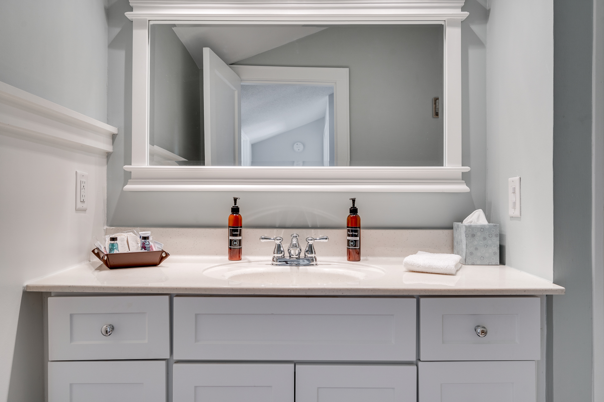 A modern bathroom vanity with stylish toiletries and a soothing color palette.