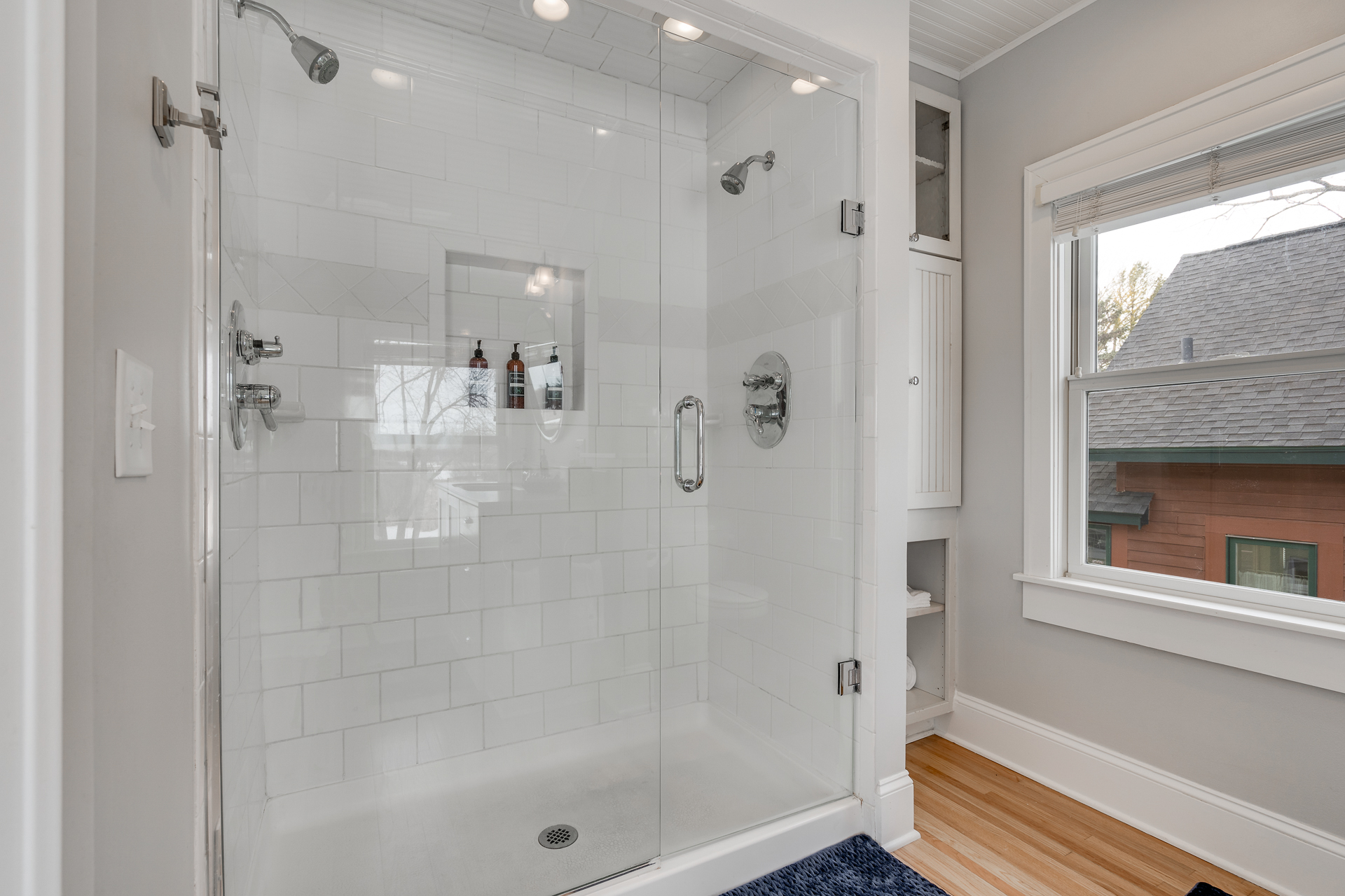 Stylish glass-enclosed shower in a modern bathroom with natural light and sleek design.