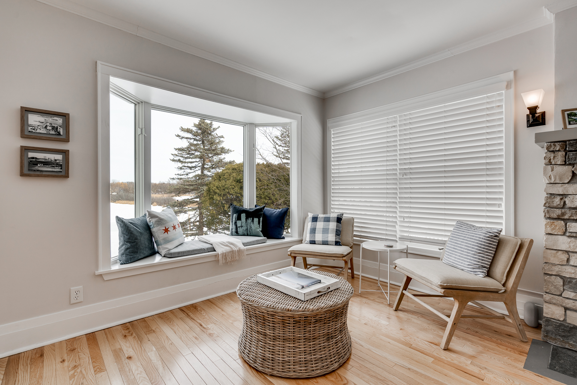 A cozy living room nook with a window seat and sleek modern chairs, offering comfort and a view.