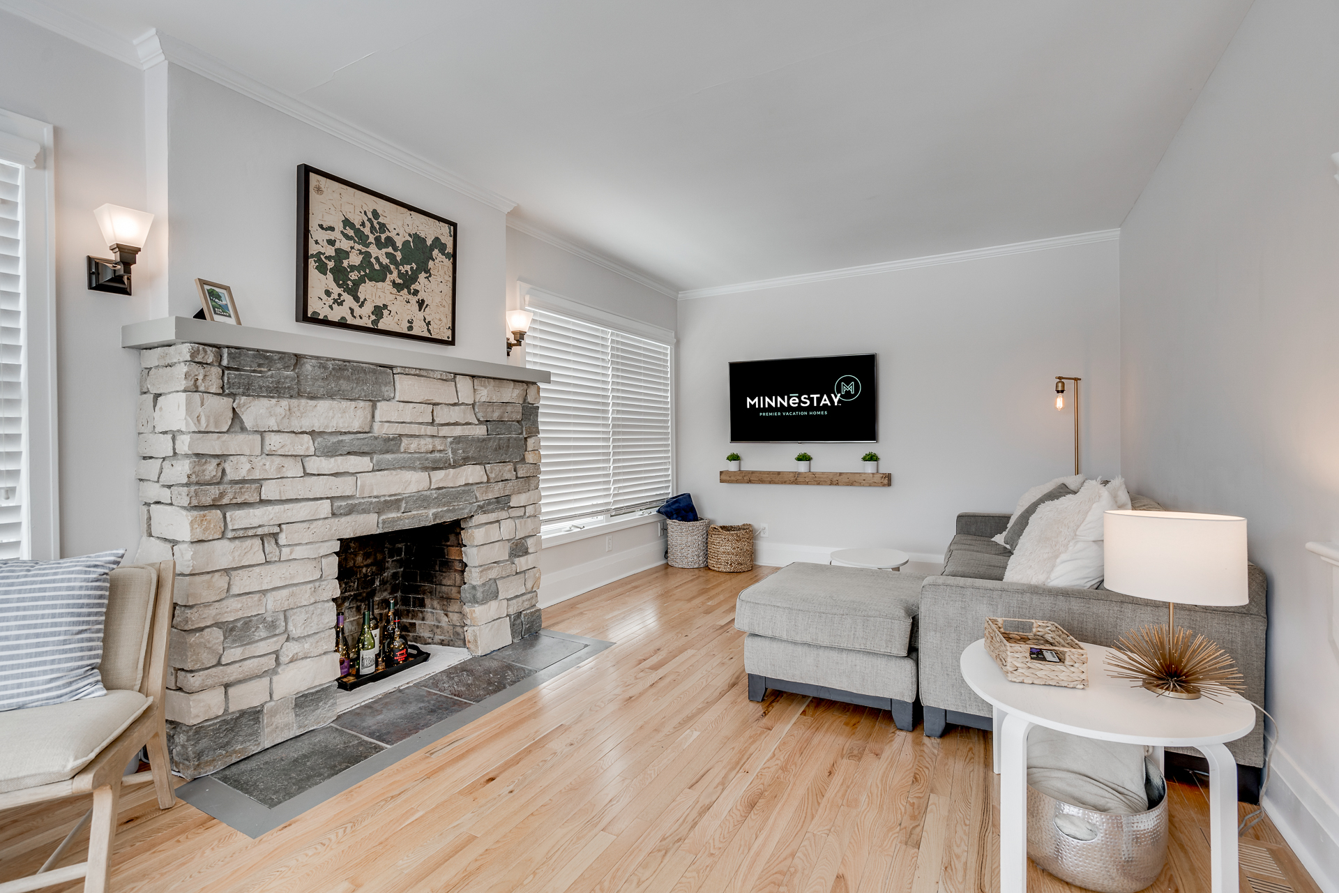 A cozy living room featuring a stone fireplace and modern decor.