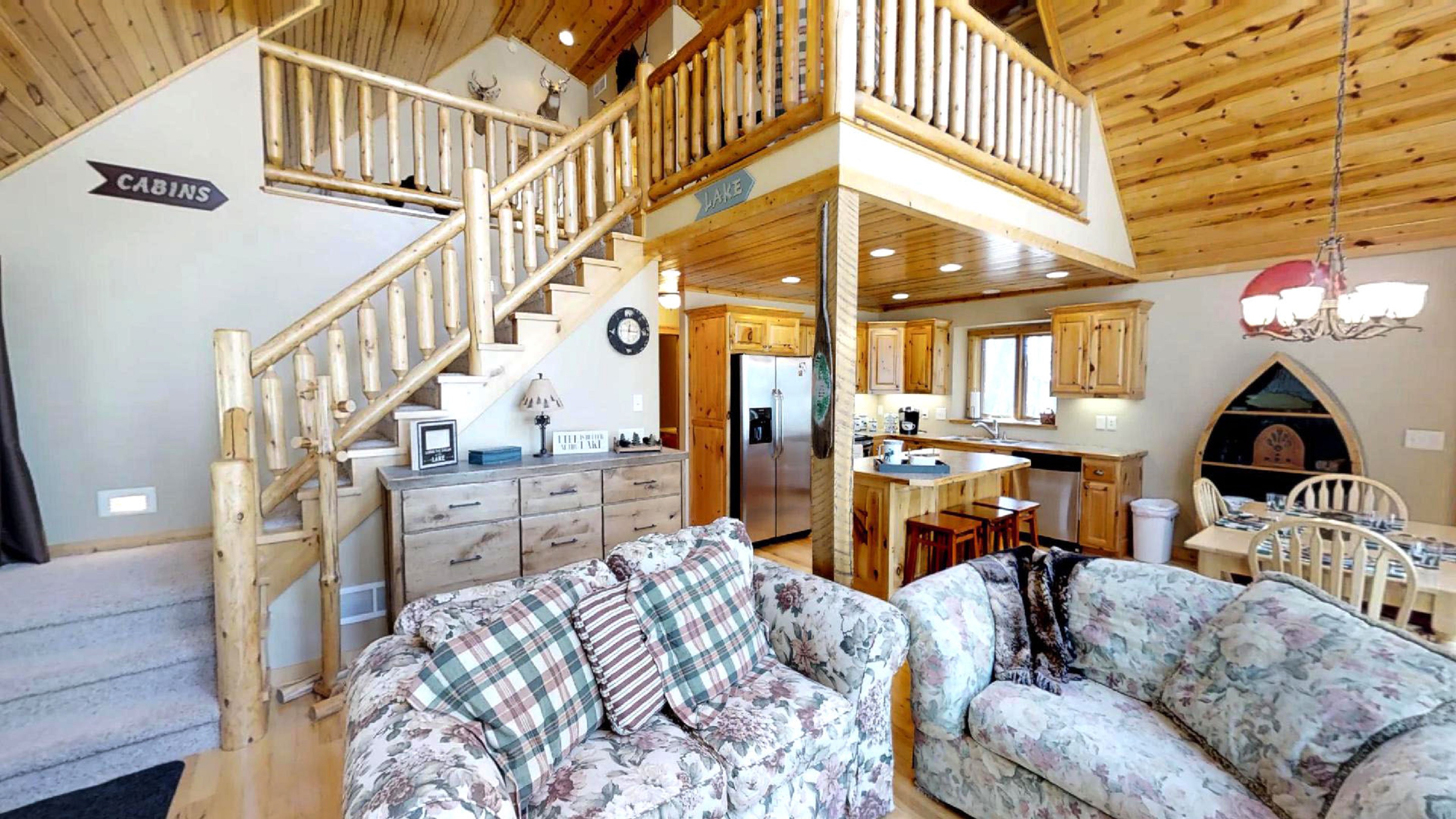 Cozy cabin interior with rustic charm, featuring a living area, kitchen, and dining area.