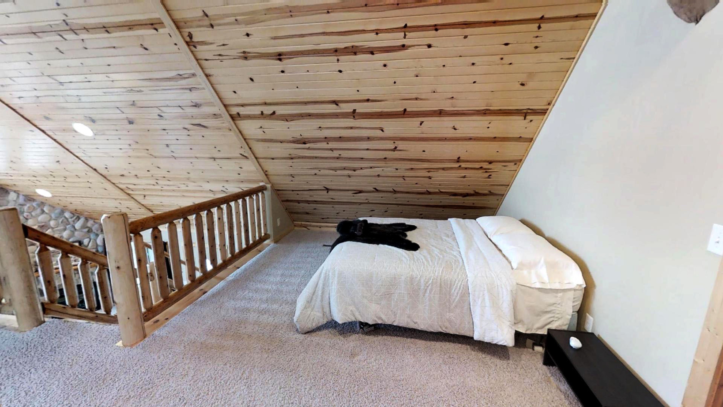 A cozy attic bedroom with wooden features and soft furnishings.