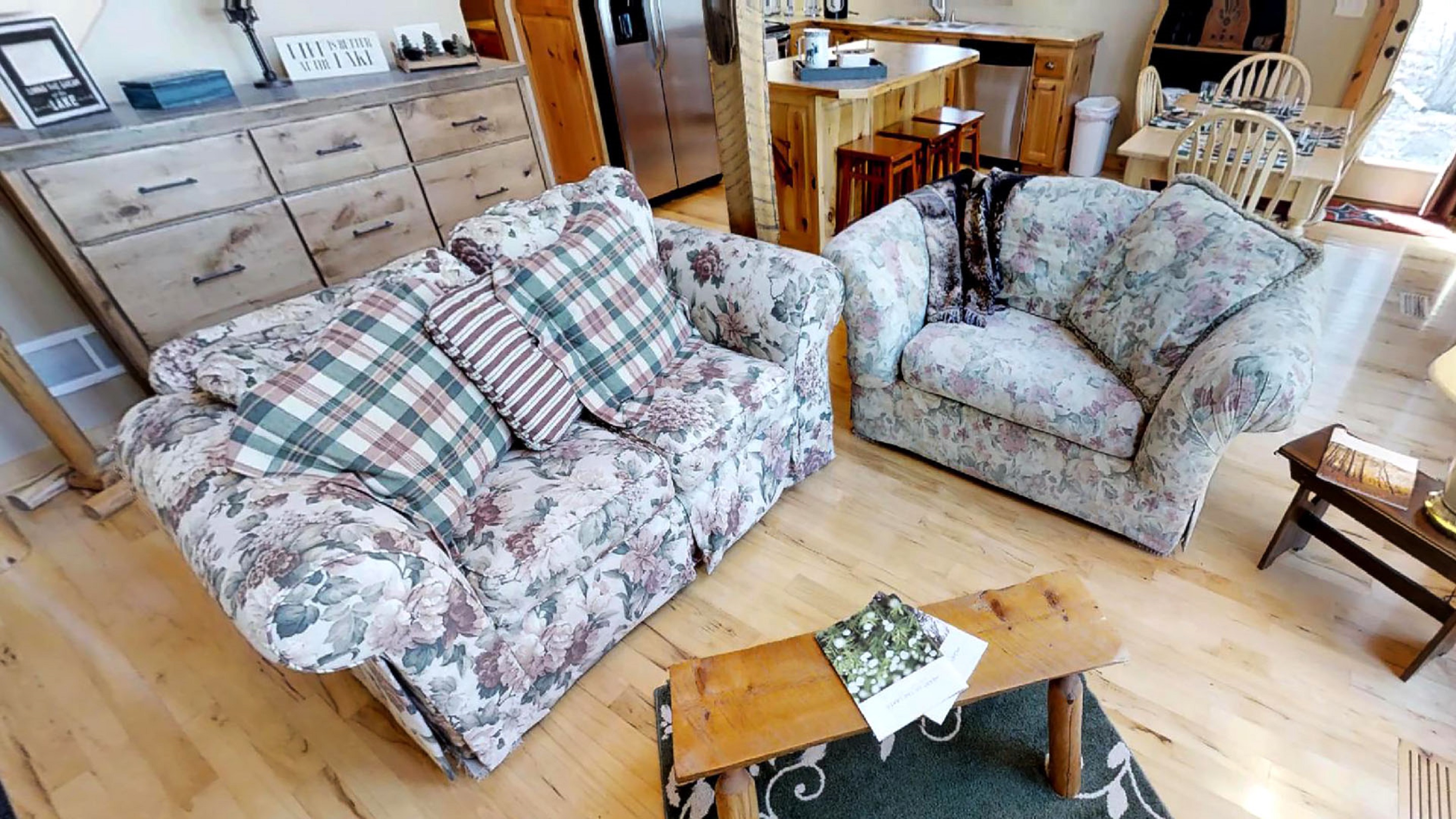 A comfortable living area featuring floral sofas and rustic decor.