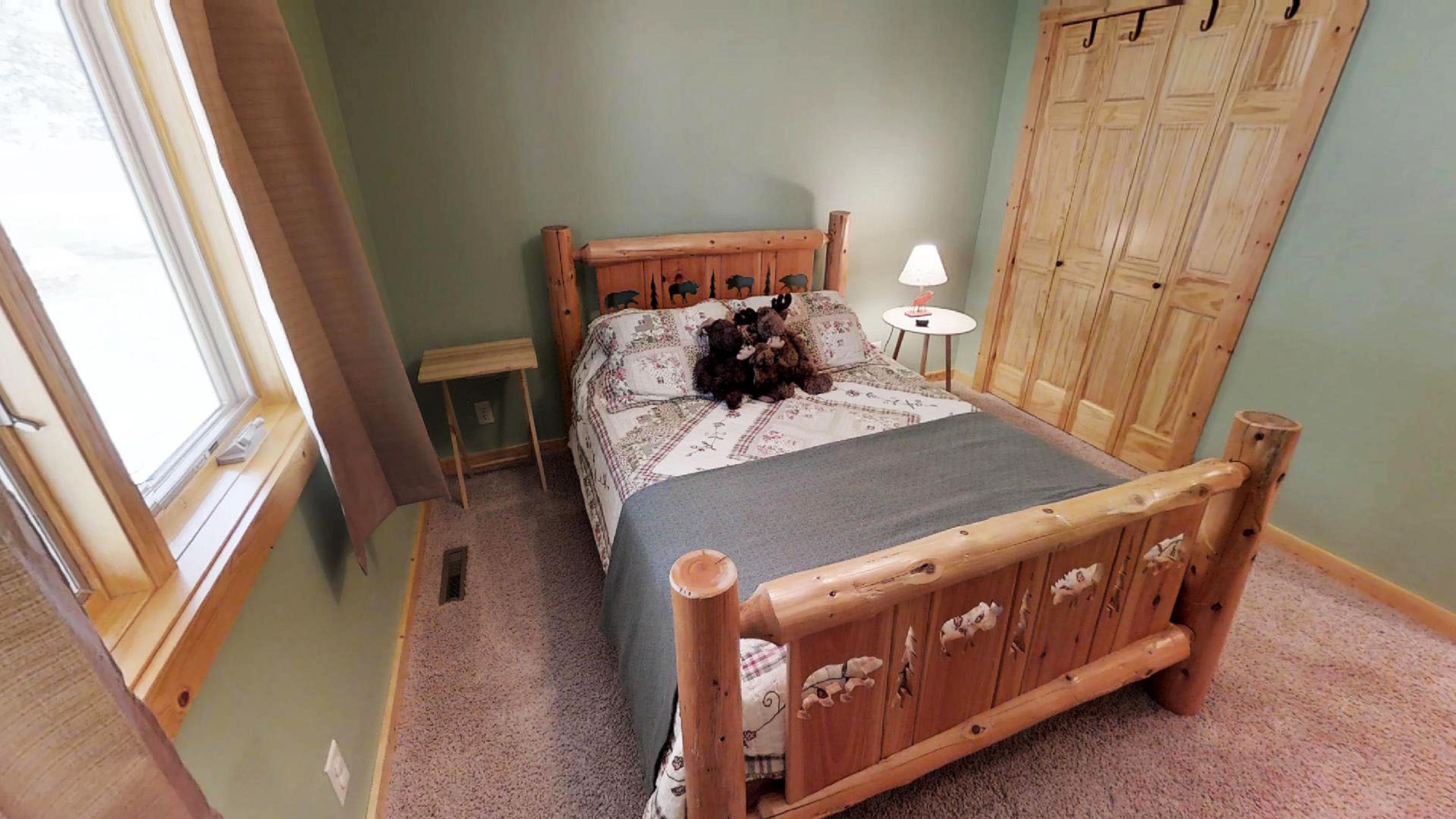 A cozy rustic bedroom with a wooden bed and plush teddy bears.