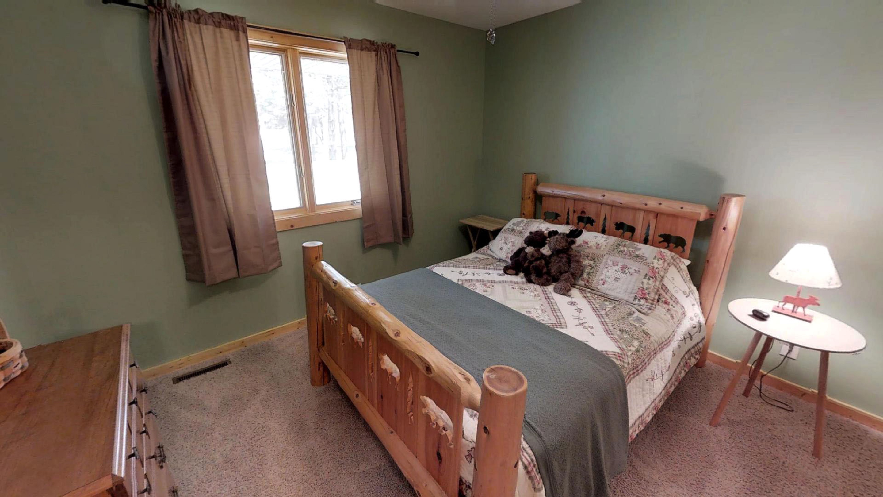 A cozy rustic bedroom with a wooden bed and warm decor.
