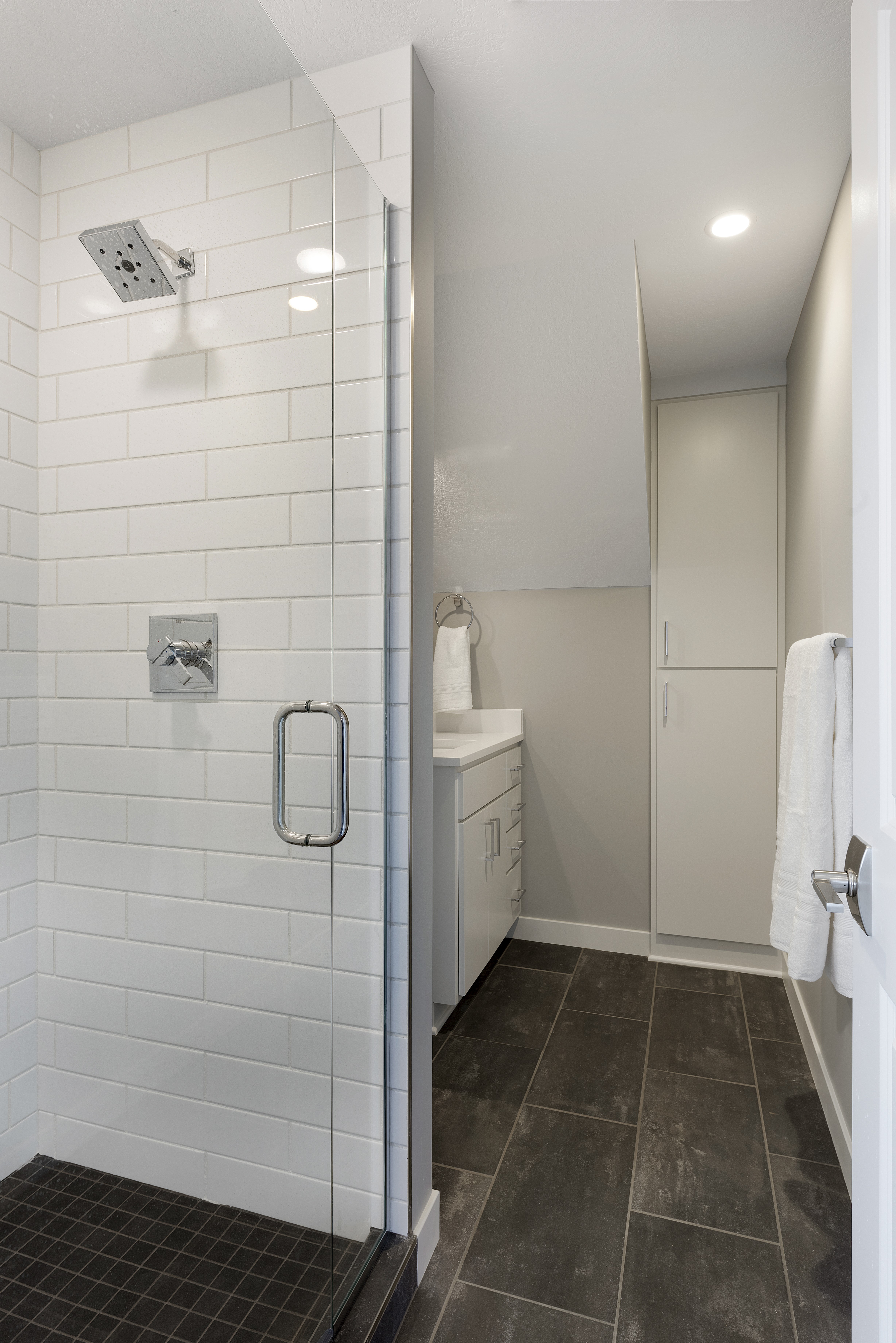 A sleek and modern bathroom featuring a stylish glass shower and contemporary vanity.