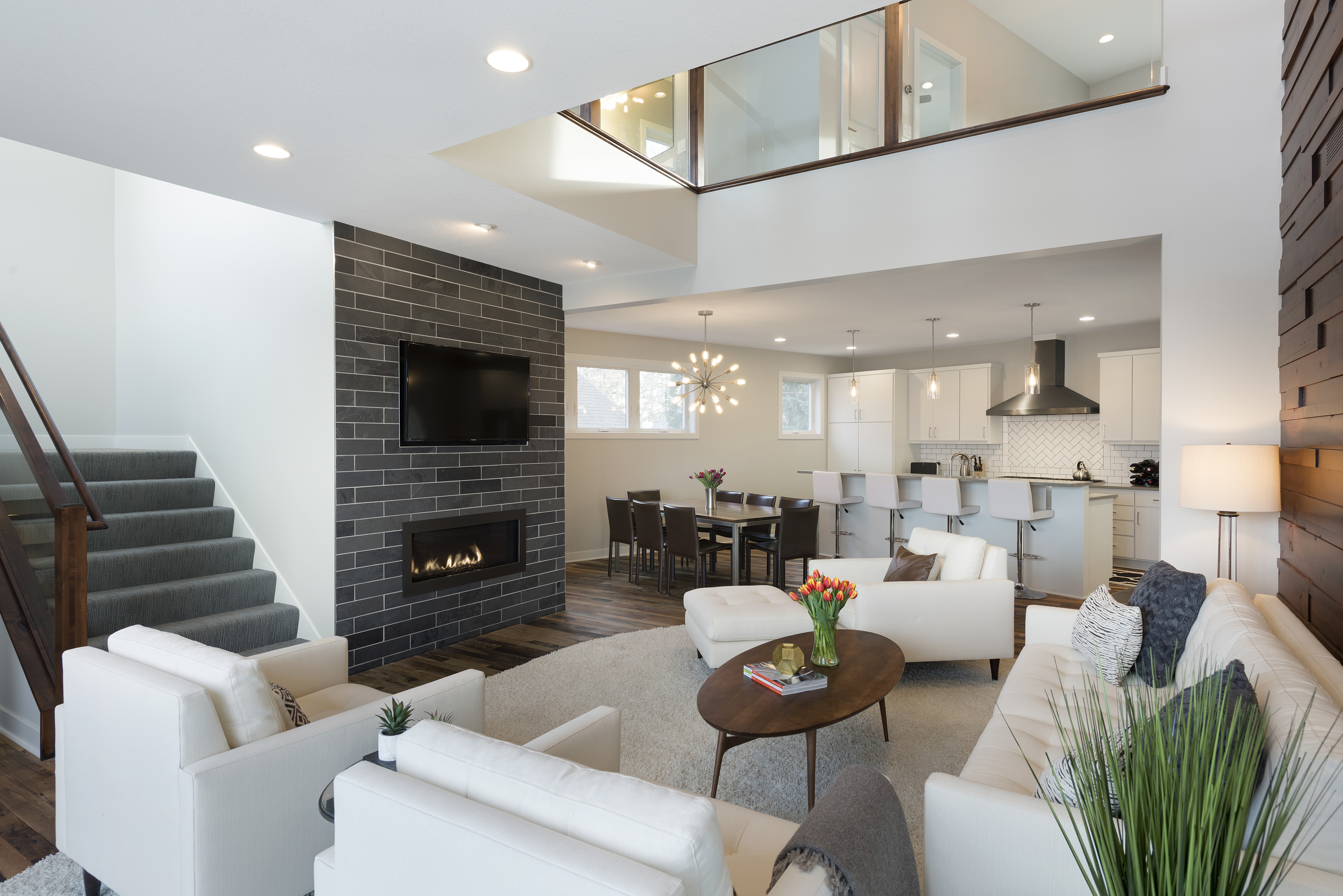 A modern living area featuring an open floor plan with cozy seating and a stylish kitchen.