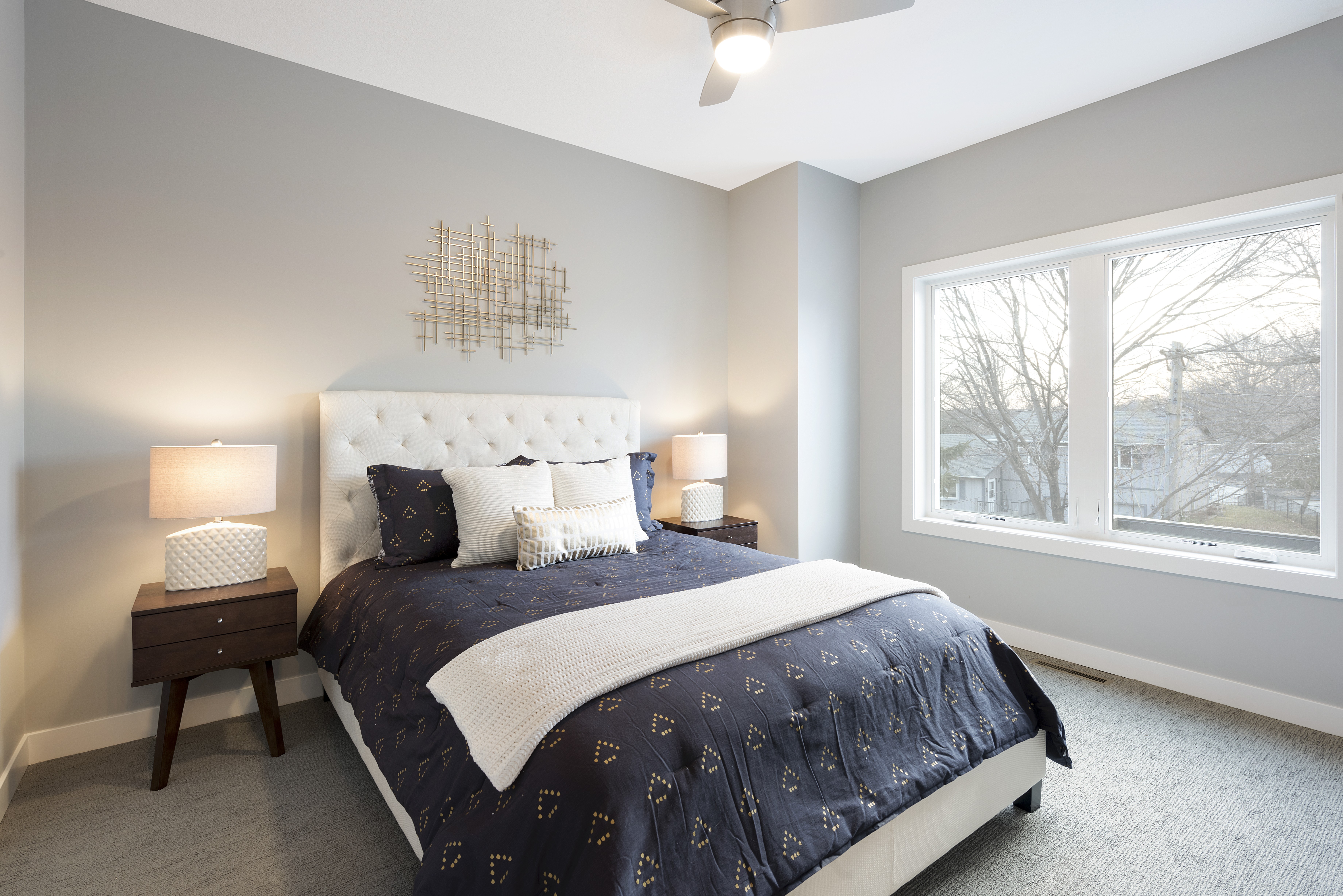 A stylish bedroom with a plush bed and modern decor, flooded with natural light.