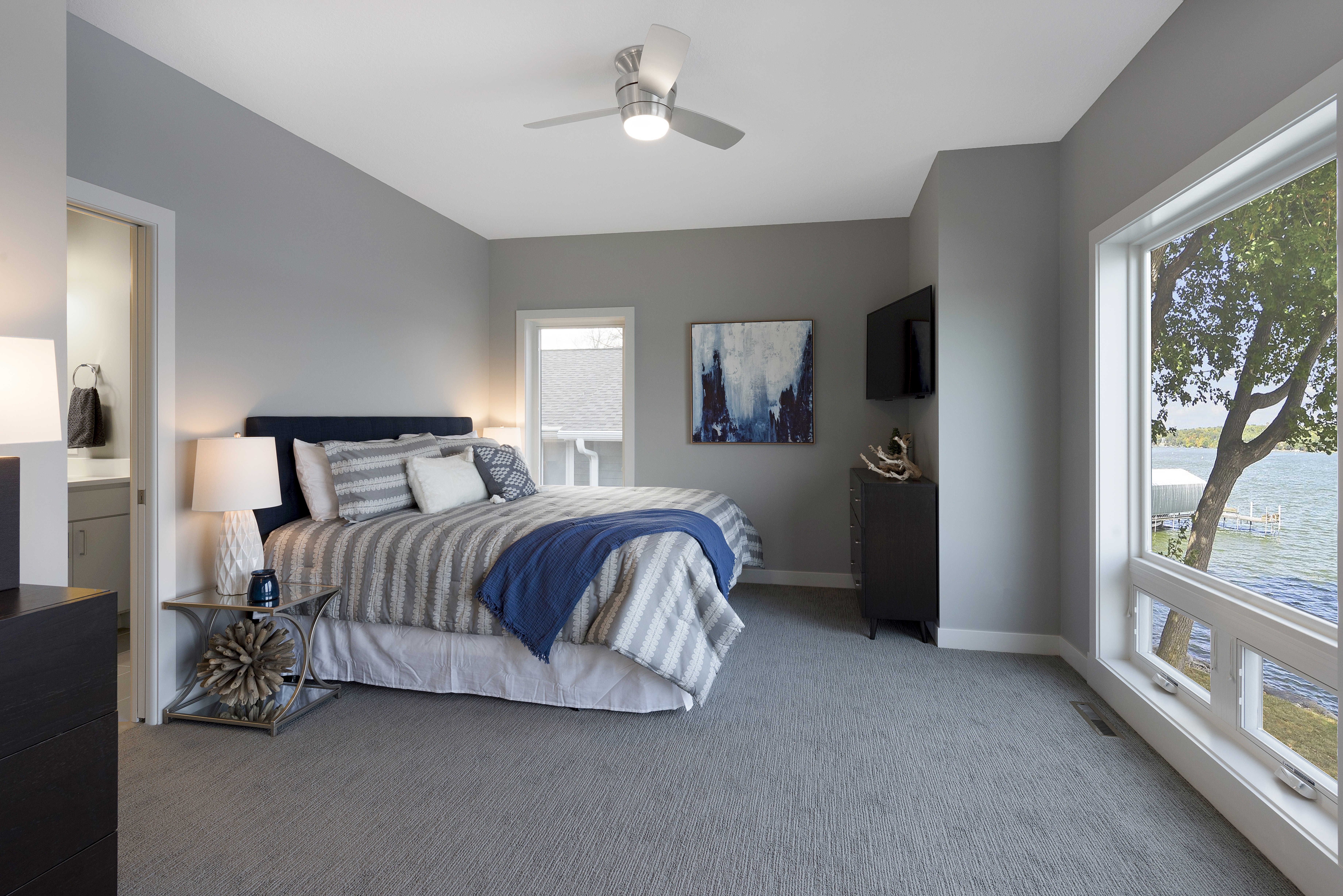 A modern and serene bedroom with lake views.