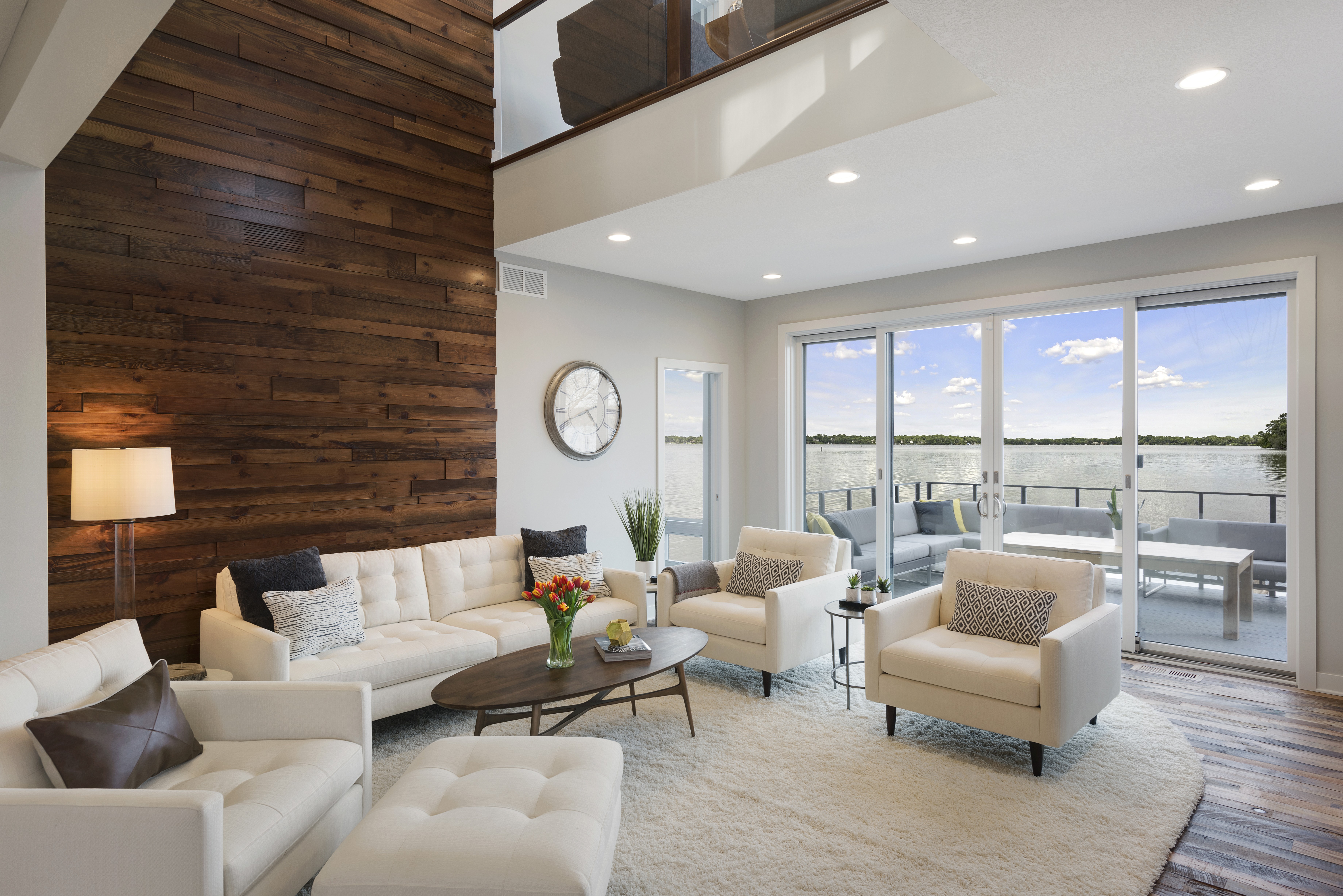 A beautifully designed living room with a view of the lake, featuring modern furniture and cozy decor.