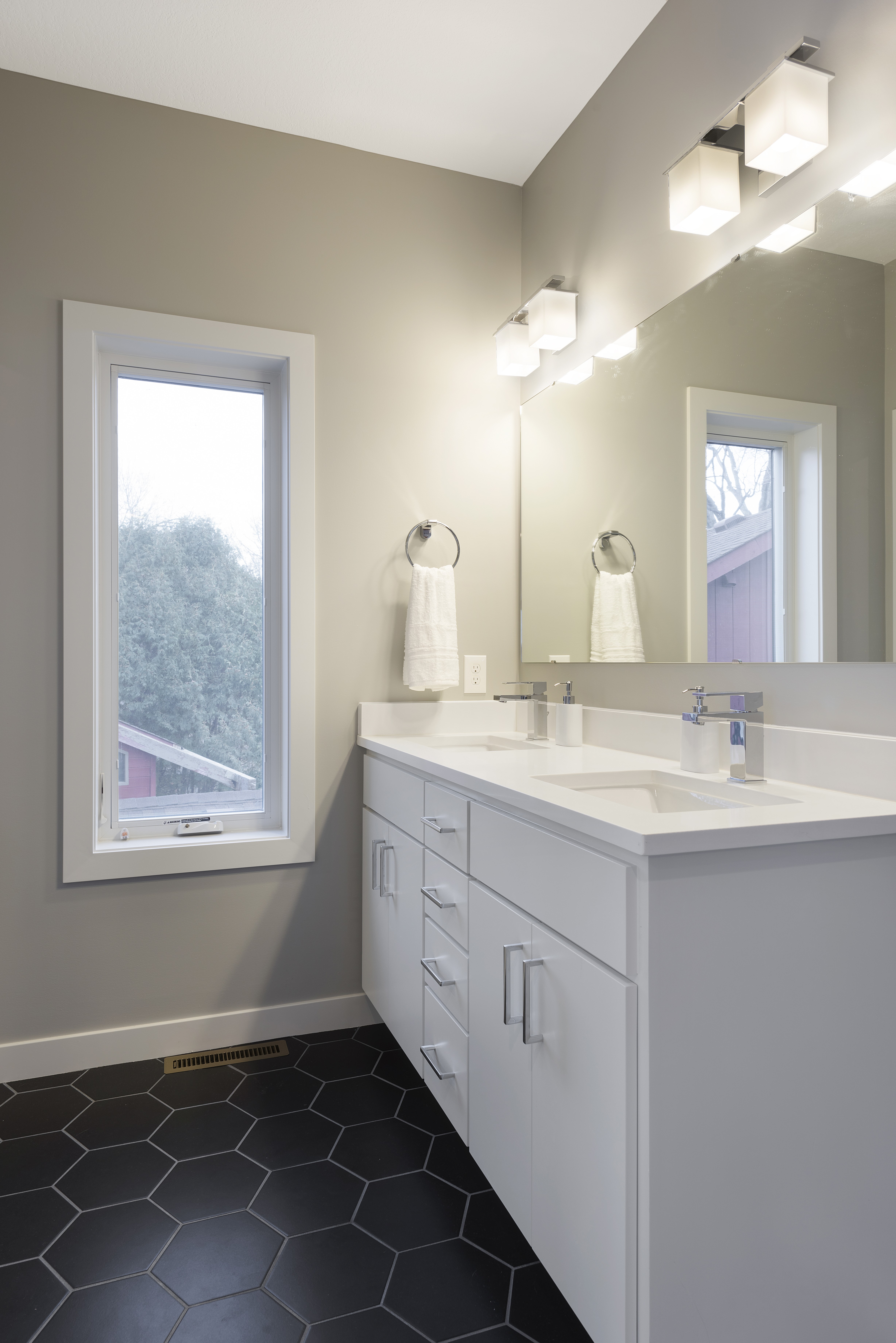 A contemporary bathroom featuring a sleek white vanity and modern fixtures.