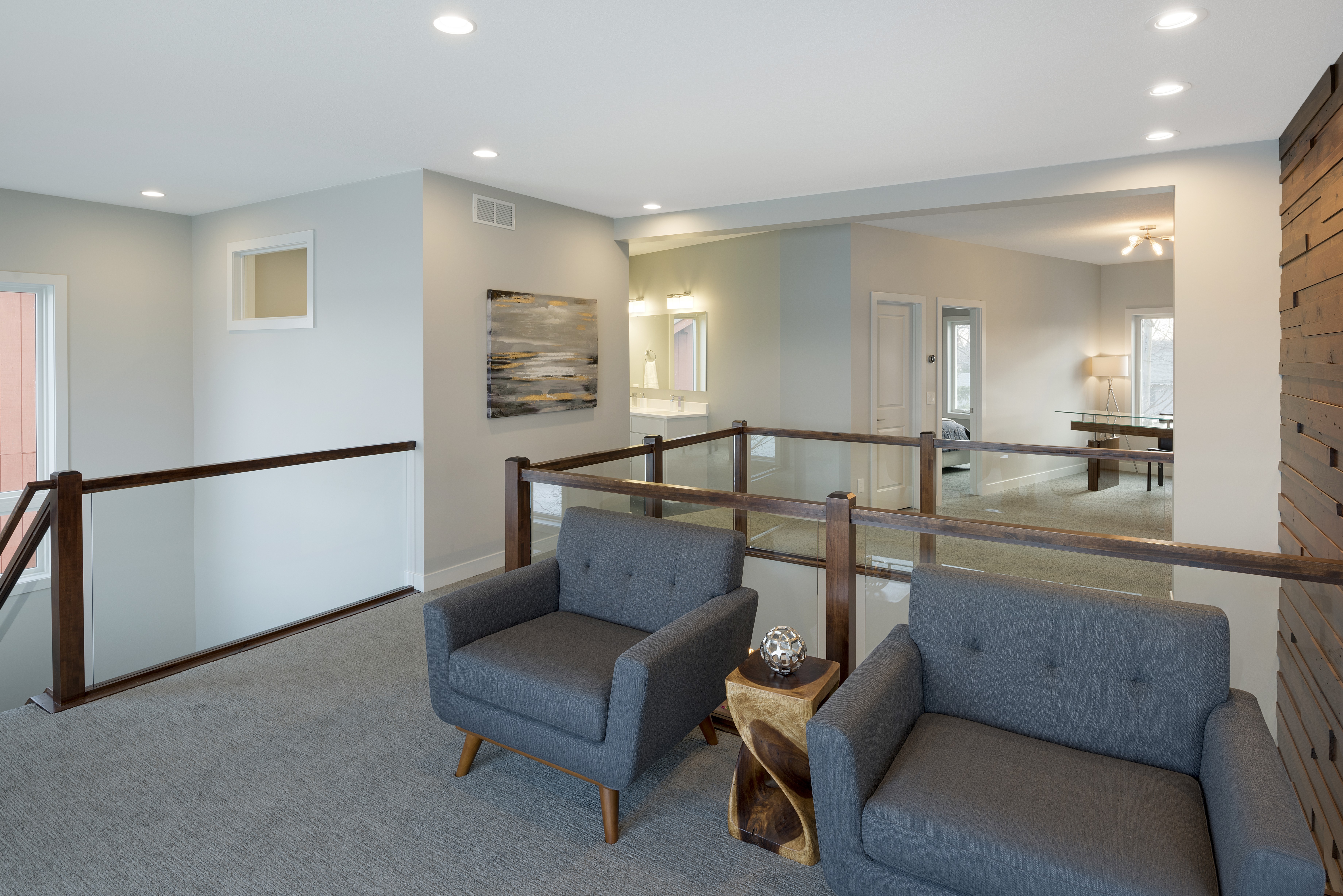 A cozy upper landing area with modern seating and natural light.