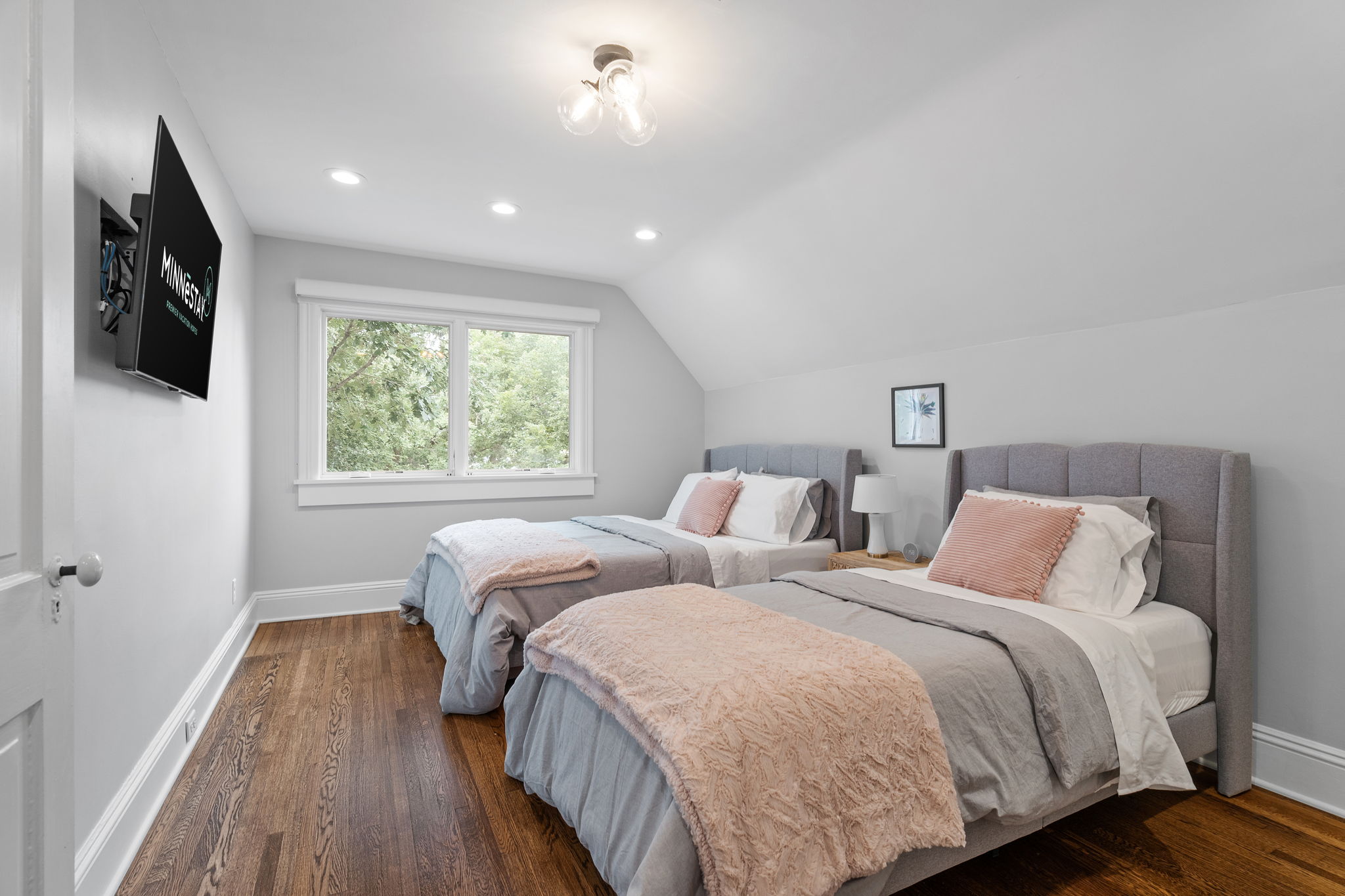 A stylish twin bedroom with modern decor and natural light.