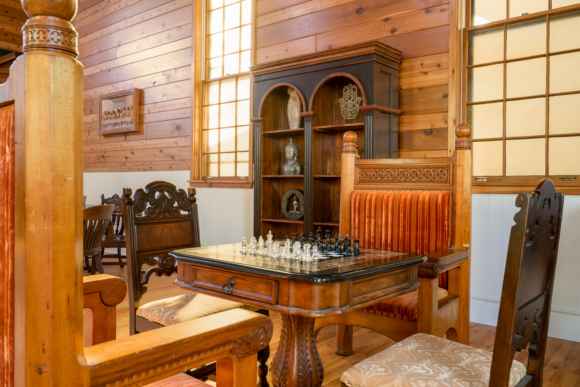 A cozy chess corner features an elegant table and ornate seating.