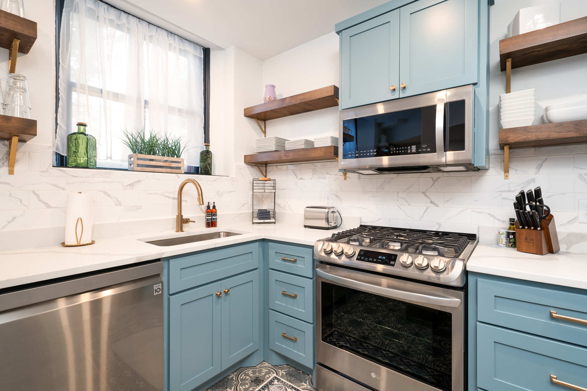 A modern kitchen with blue cabinetry and elegant features.