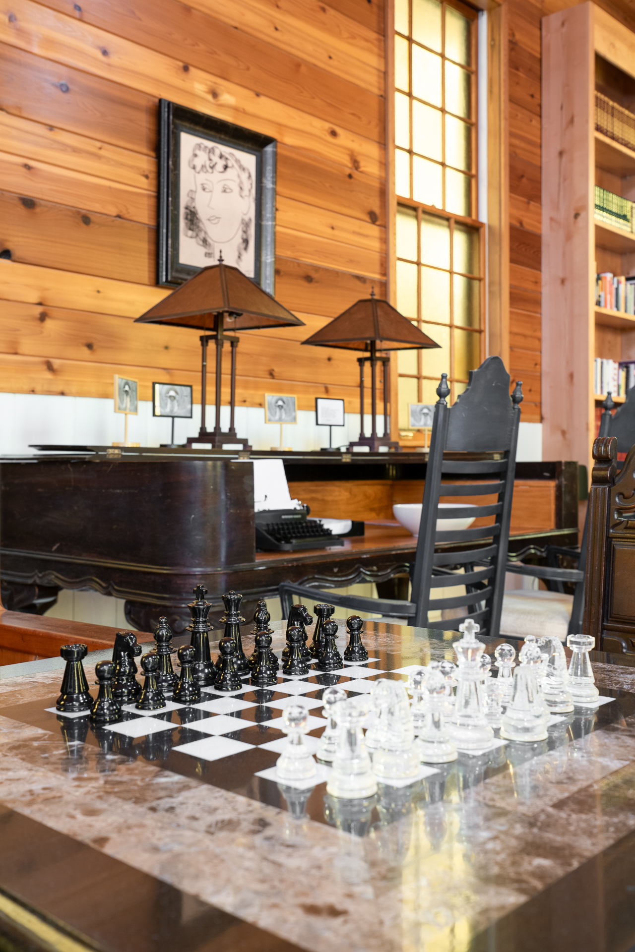 An elegant chess set awaits a match in a warmly lit, vintage-inspired interior.