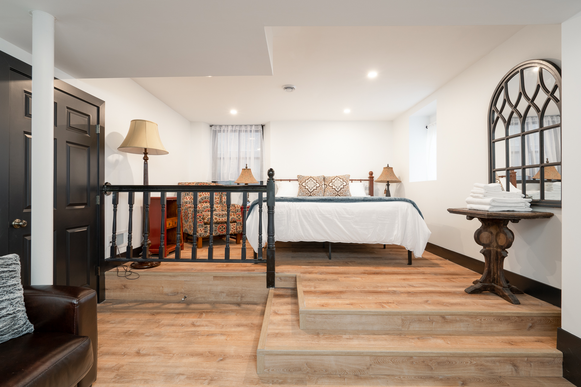 A stylish basement room with cozy seating and modern decor.