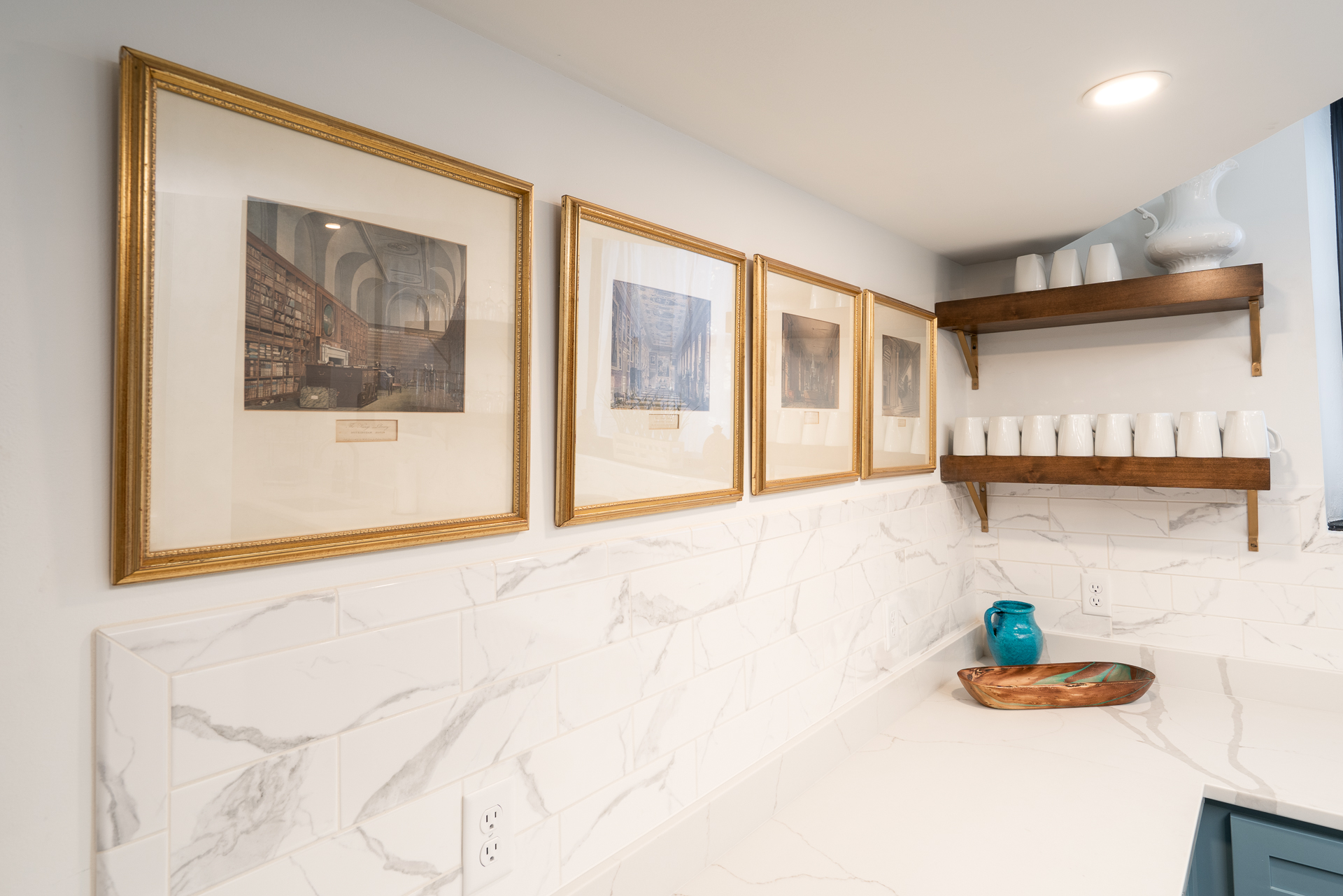 Elegant kitchen corner with framed artwork and neatly arranged ceramics.