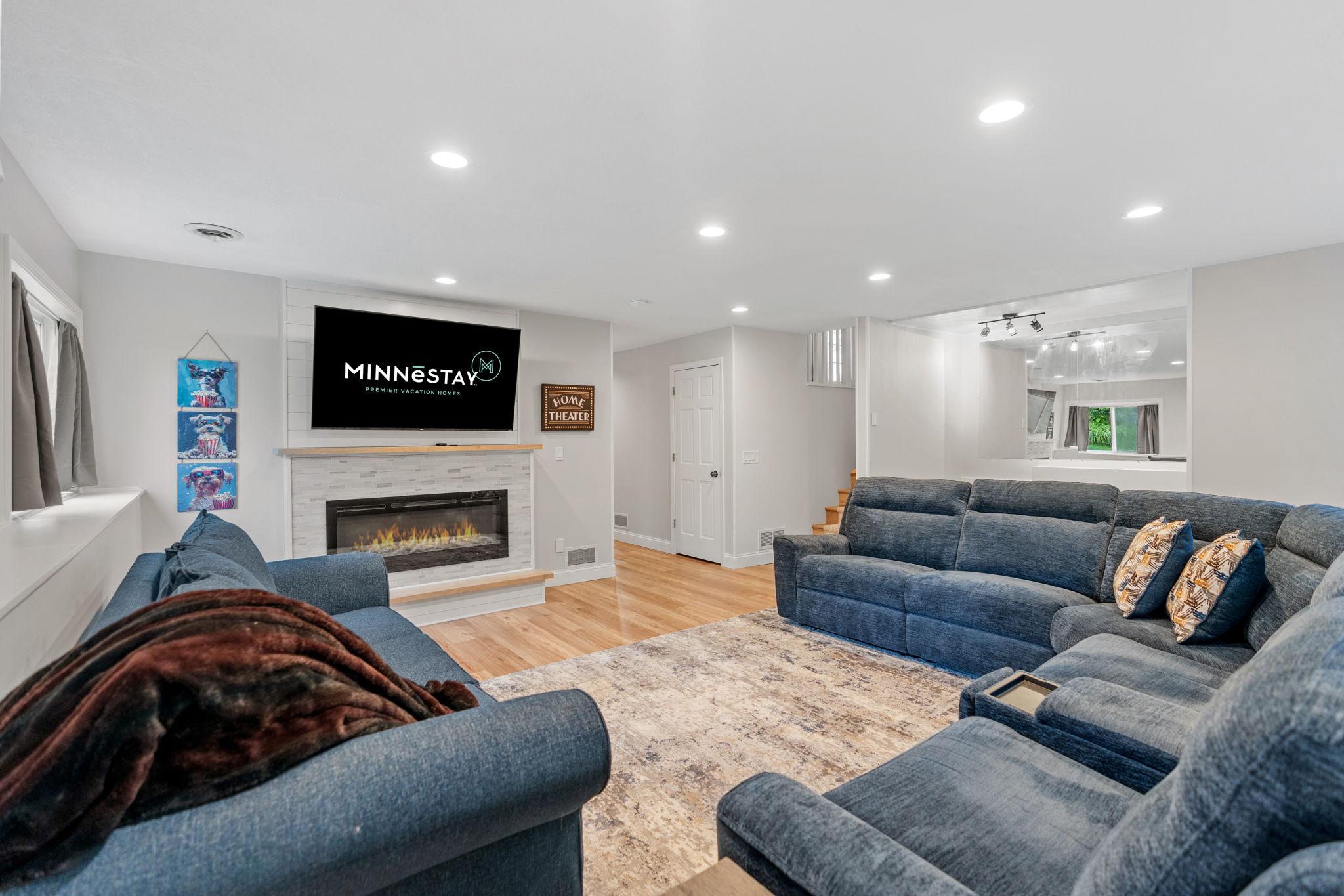 Modern living room with a blue sectional sofa, fireplace, and TV