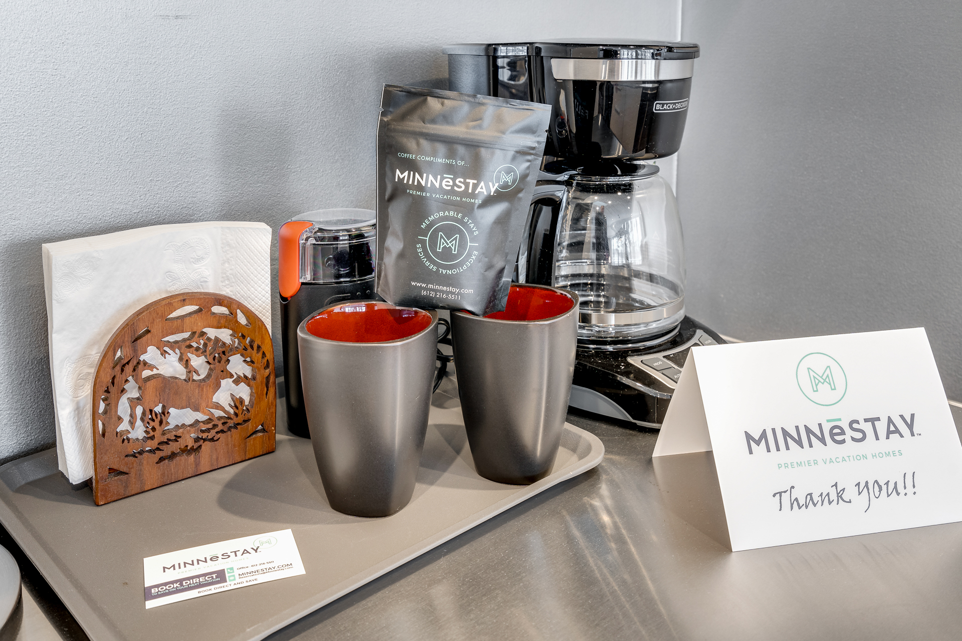 A welcoming coffee station featuring MINNESTAY coffee, cups, and a thank you card.