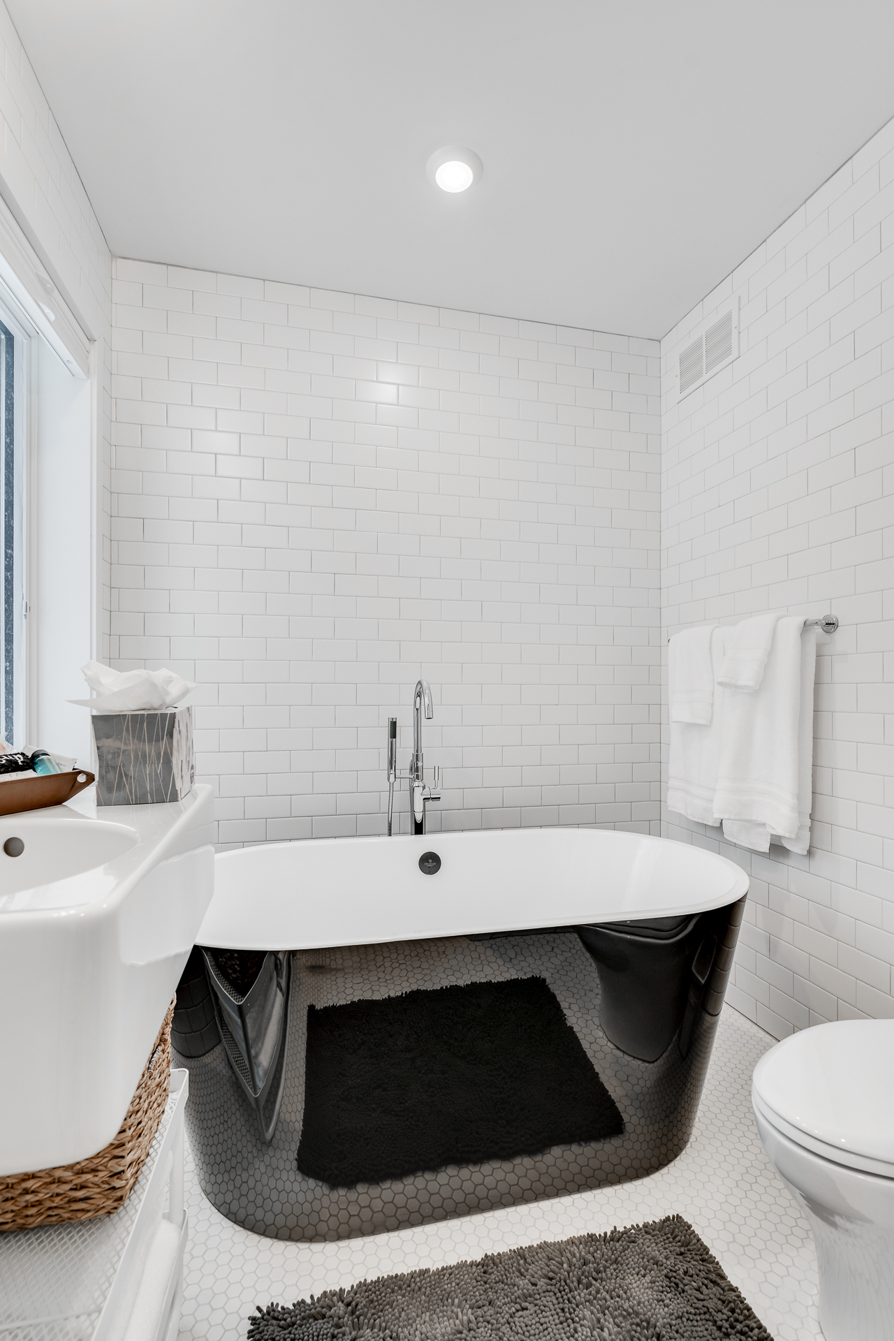 A modern bathroom featuring a stylish black and white bath design.