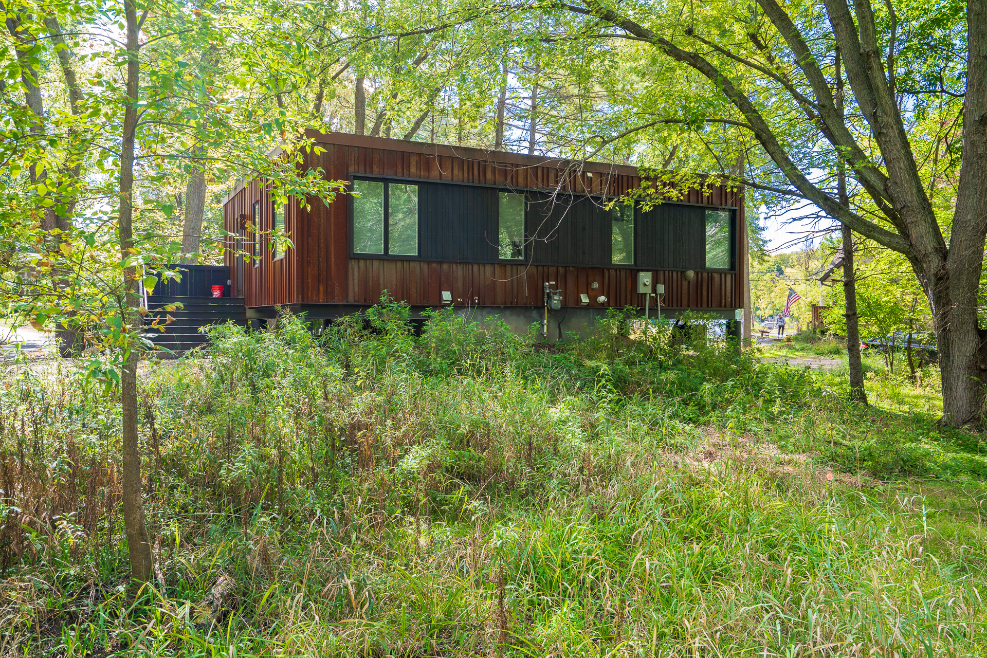 A modern wooden house surrounded by lush greenery.